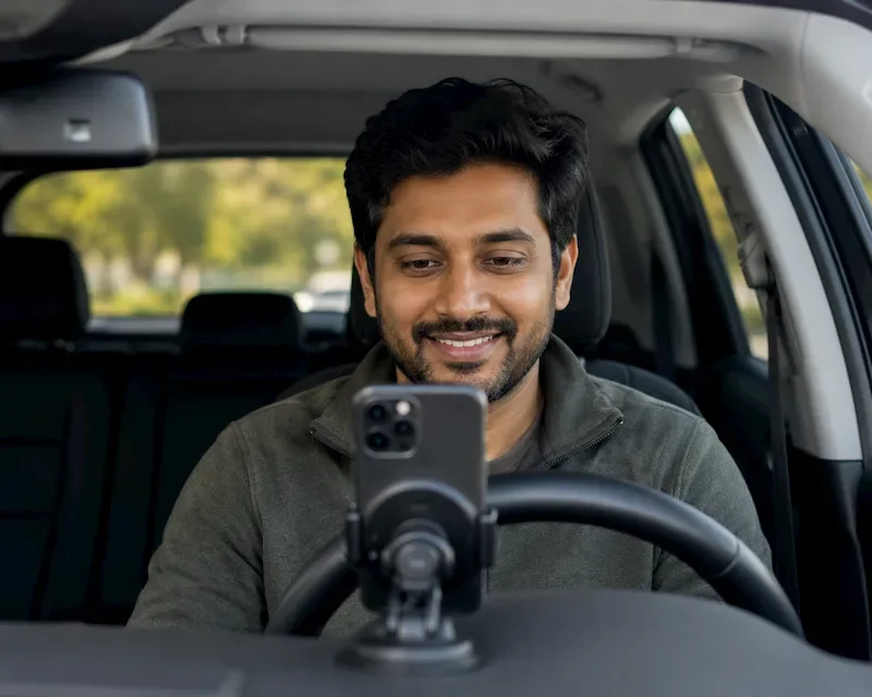 man in car doing a telehealth counseling session from his phone