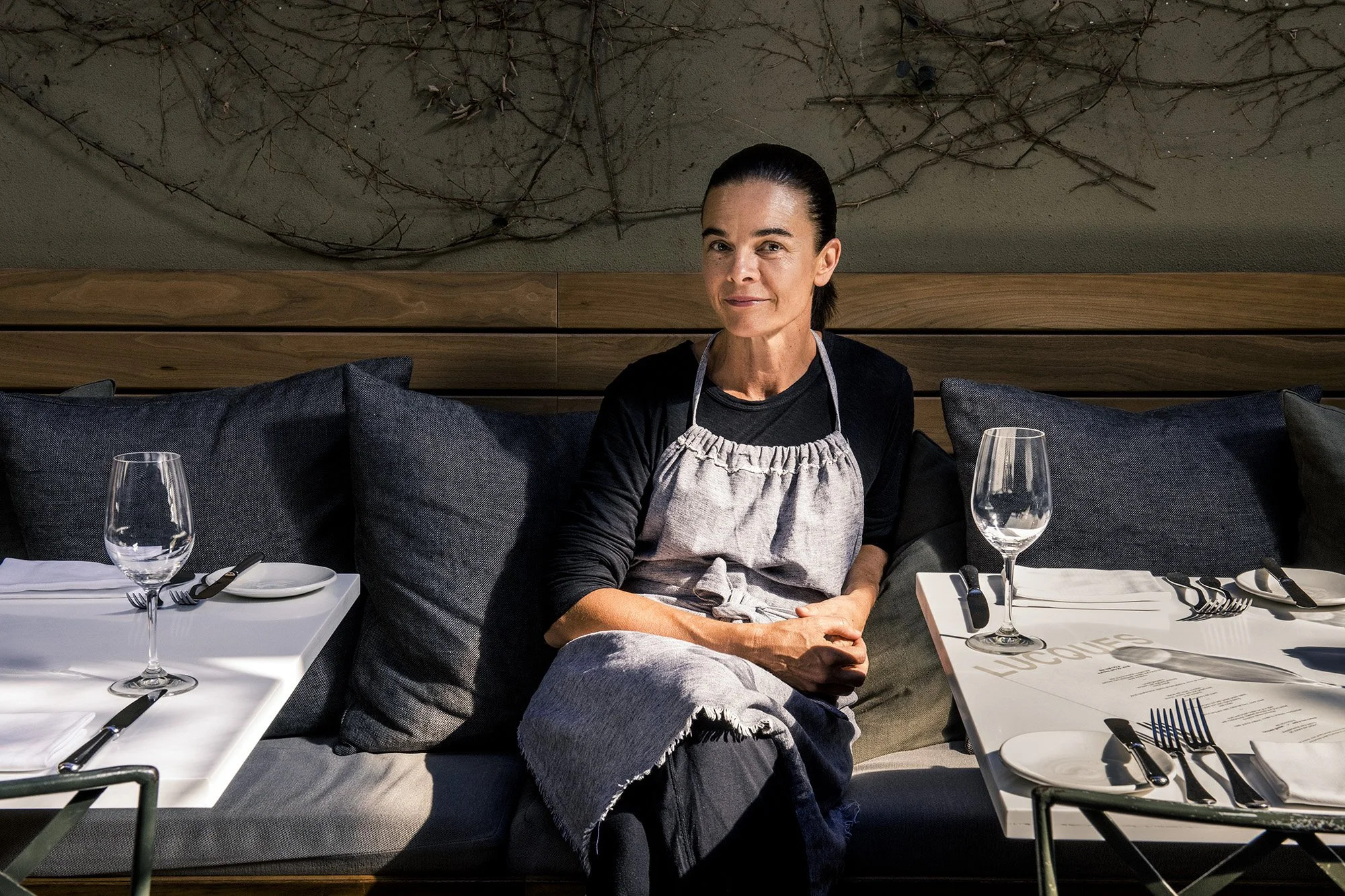 James Beard award winning chef Suzanne Goin sitting on a banquette at Lucques restaurant