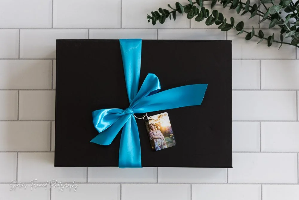 Stories Framed Photography senior album in a black gift box with turquoise ribbon and a photo keychain, Milwaukee senior photographer