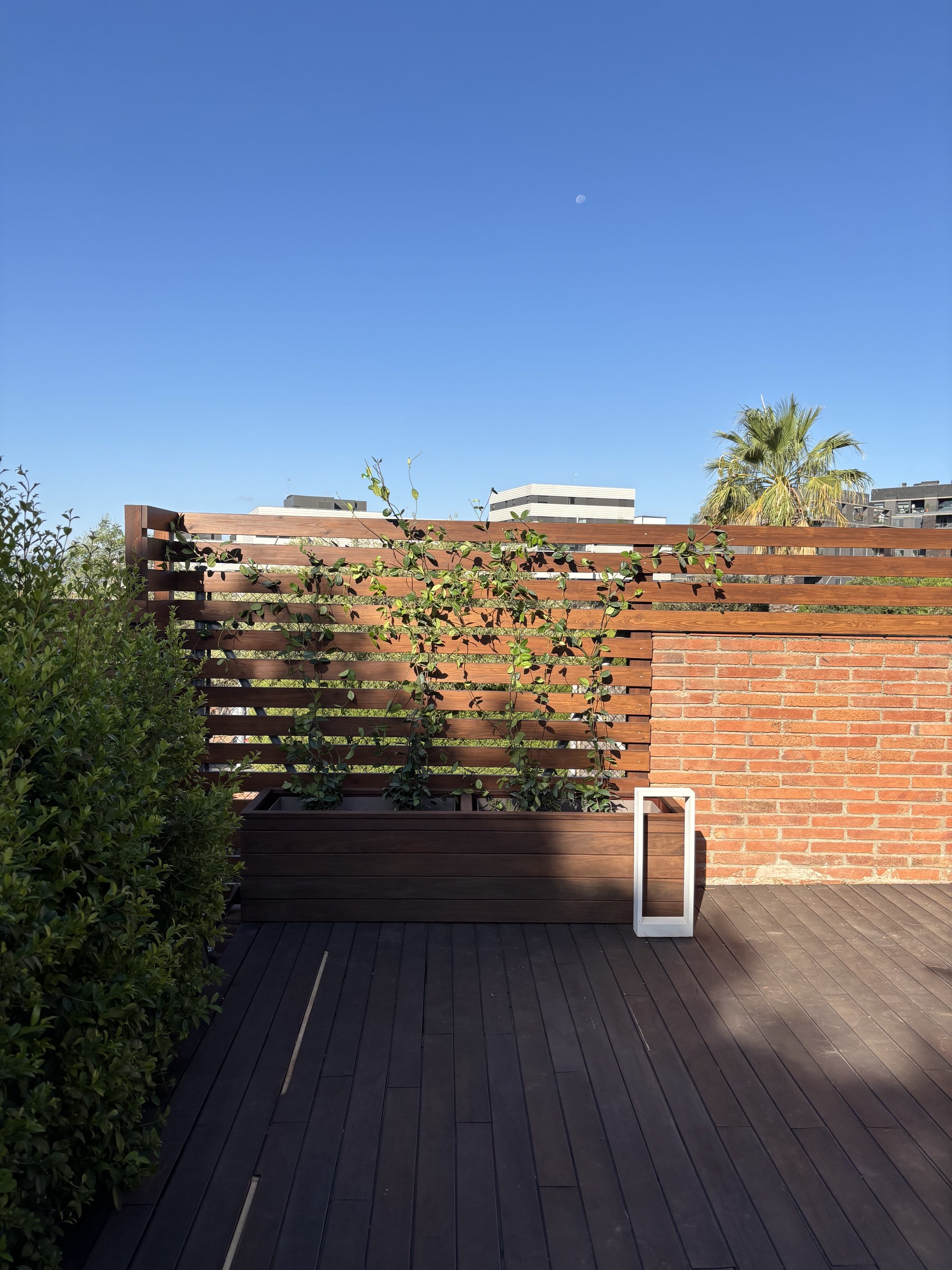 Terraza en madera de ipe con jardinera a medida forrada en madera