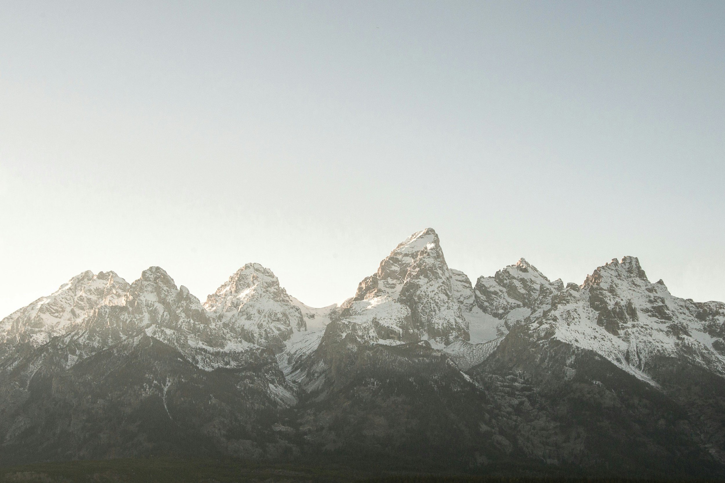 Snow-capped mountain range under a clear sky.