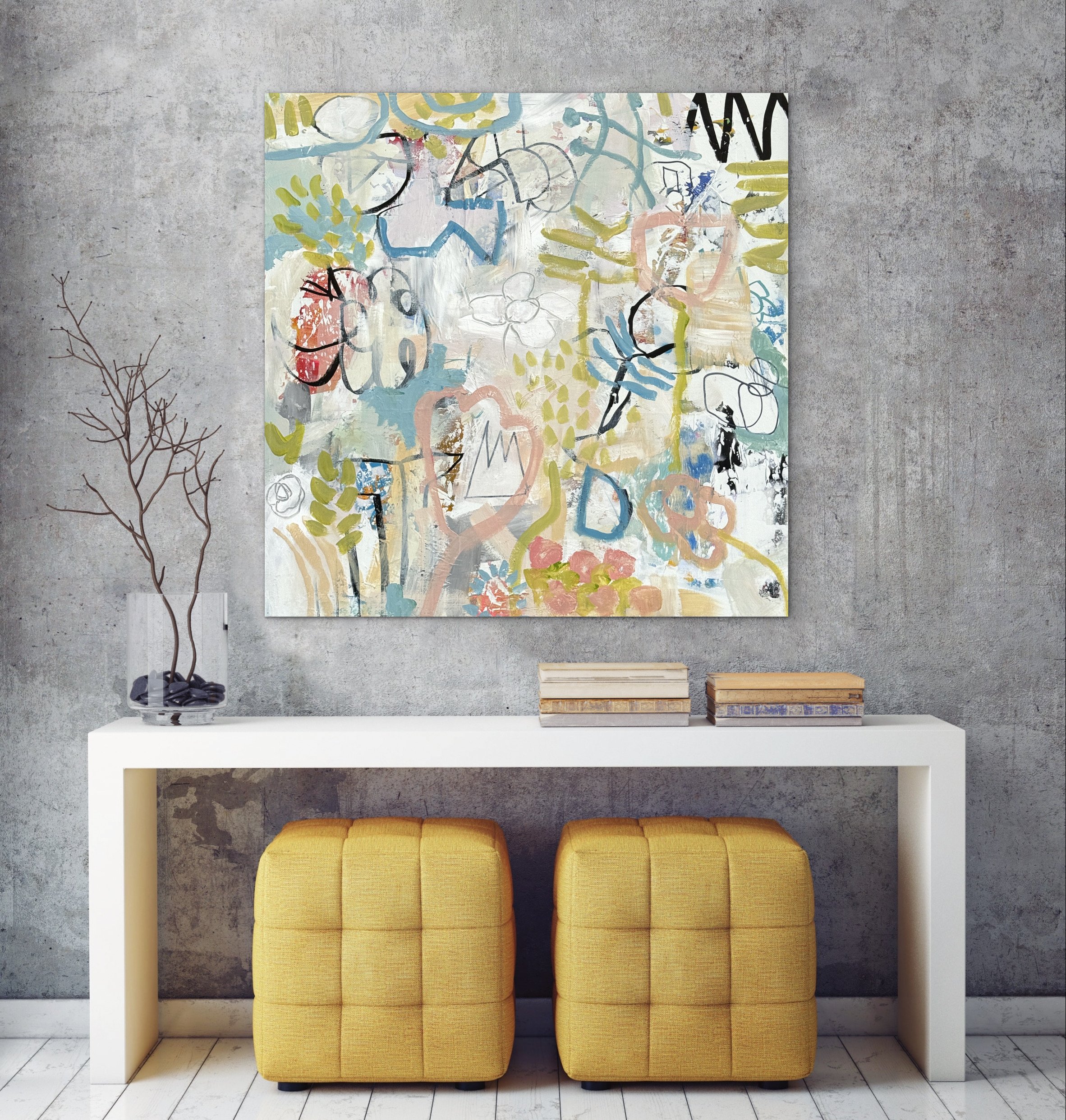 Too Many Good Things by Elizabeth Williams displayed above a white console table with two mustard-yellow ottomans against a textured gray wall.