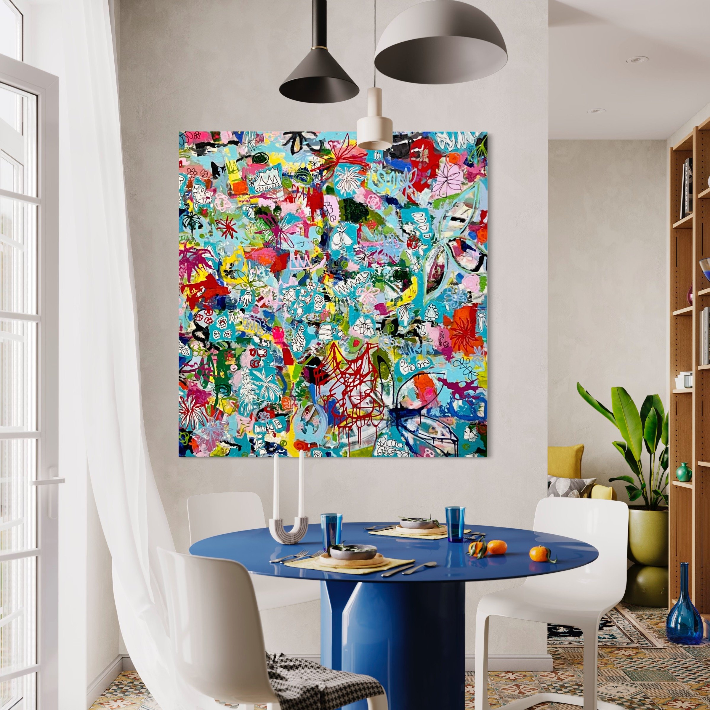 A colorful abstract painting hangs on a light-colored wall in a modern dining area with a blue round table, white chairs, a black and white patterned chair, and some vegetables on the table.
