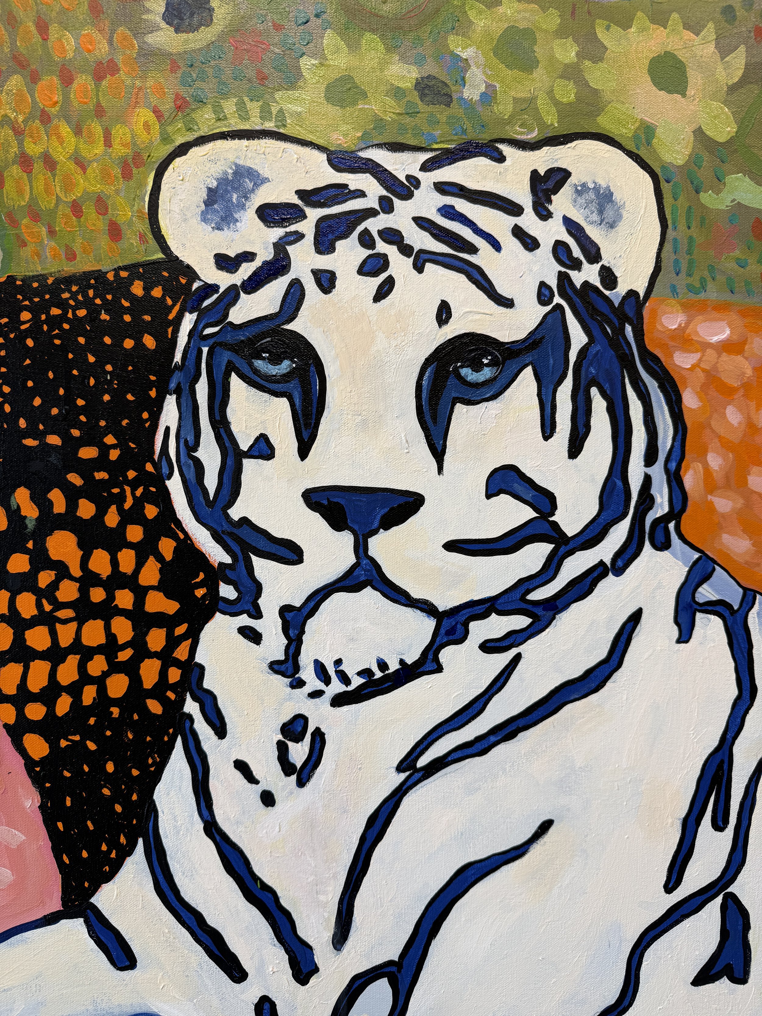 Detail of the tiger in The Sofa Situation, against patterned black, orange, and pink upholstery.