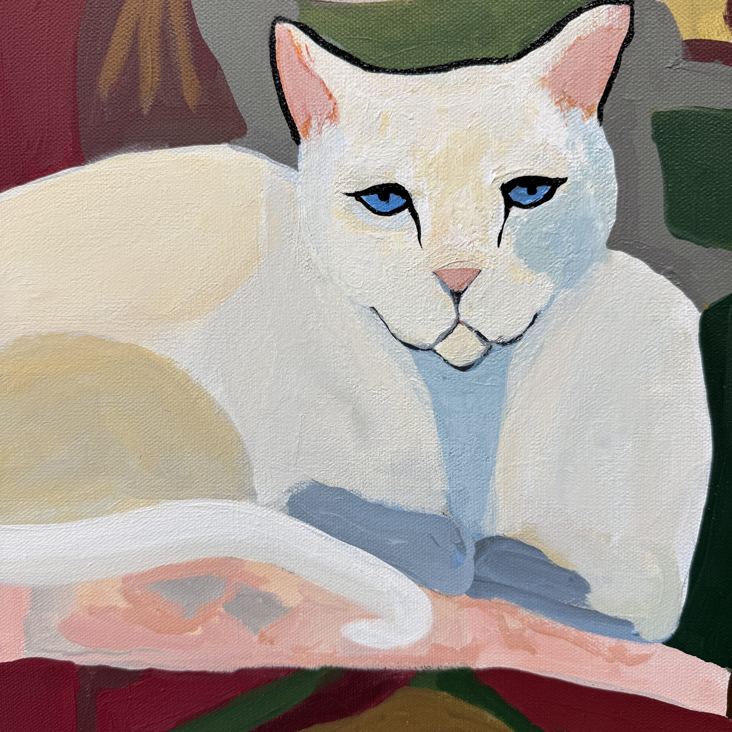 Detail of the white cat resting in a richly colored interior.