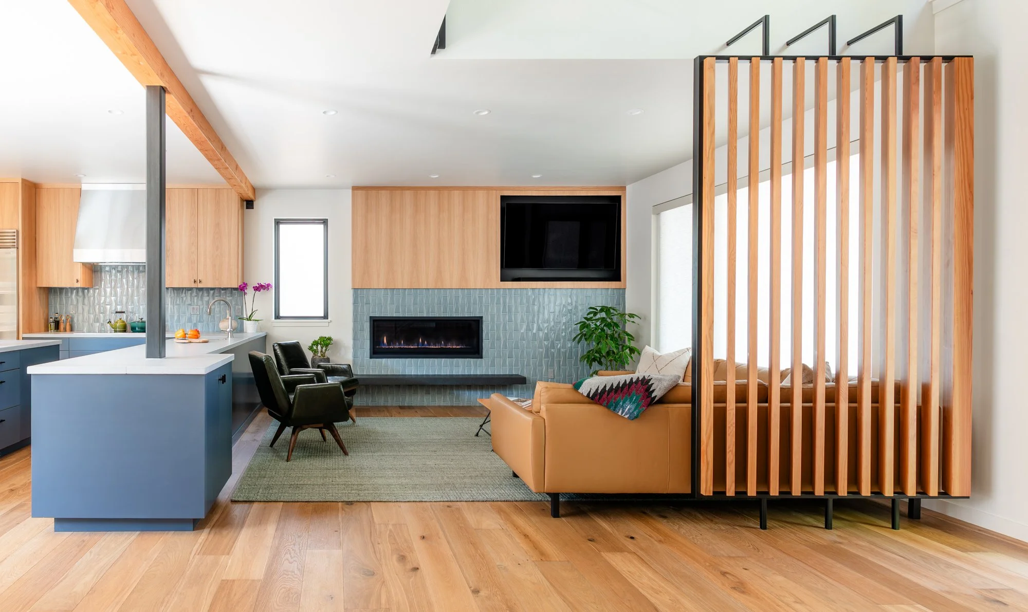 Bright living room and kitchen with wood accents and tiled fireplace