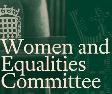 Close-up of a green and white banner with the text 'Women and Equalities Committee' and a crown symbol, indicating it relates to a governmental or parliamentary group.