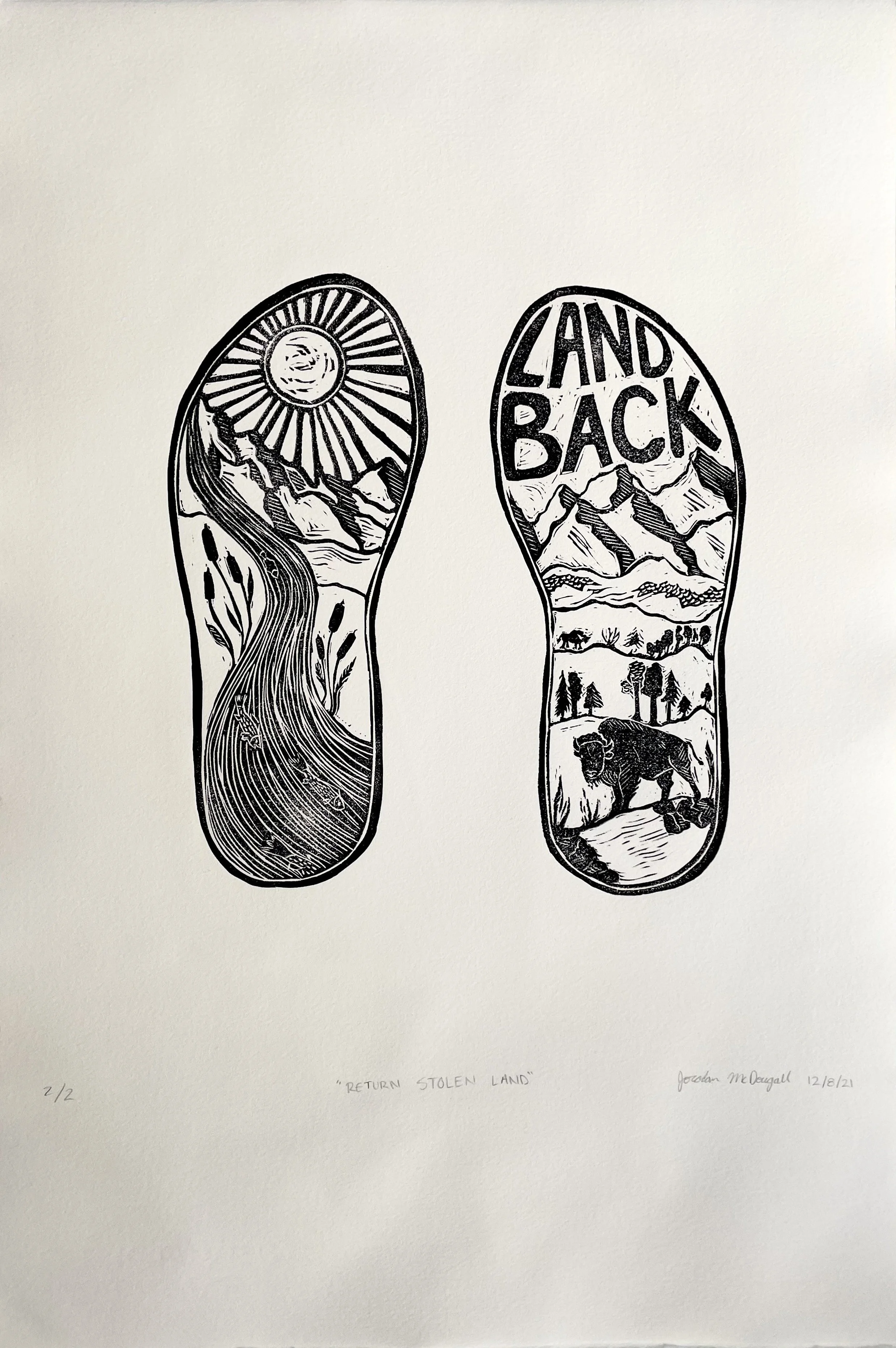 A black linocut of shoe prints on white paper. The shoe print on the left is filled with a sunny sky and a river surrounded by mountains and grasses. The right shoe print has the text "Land Back" at the top and features a bison in the mountains.