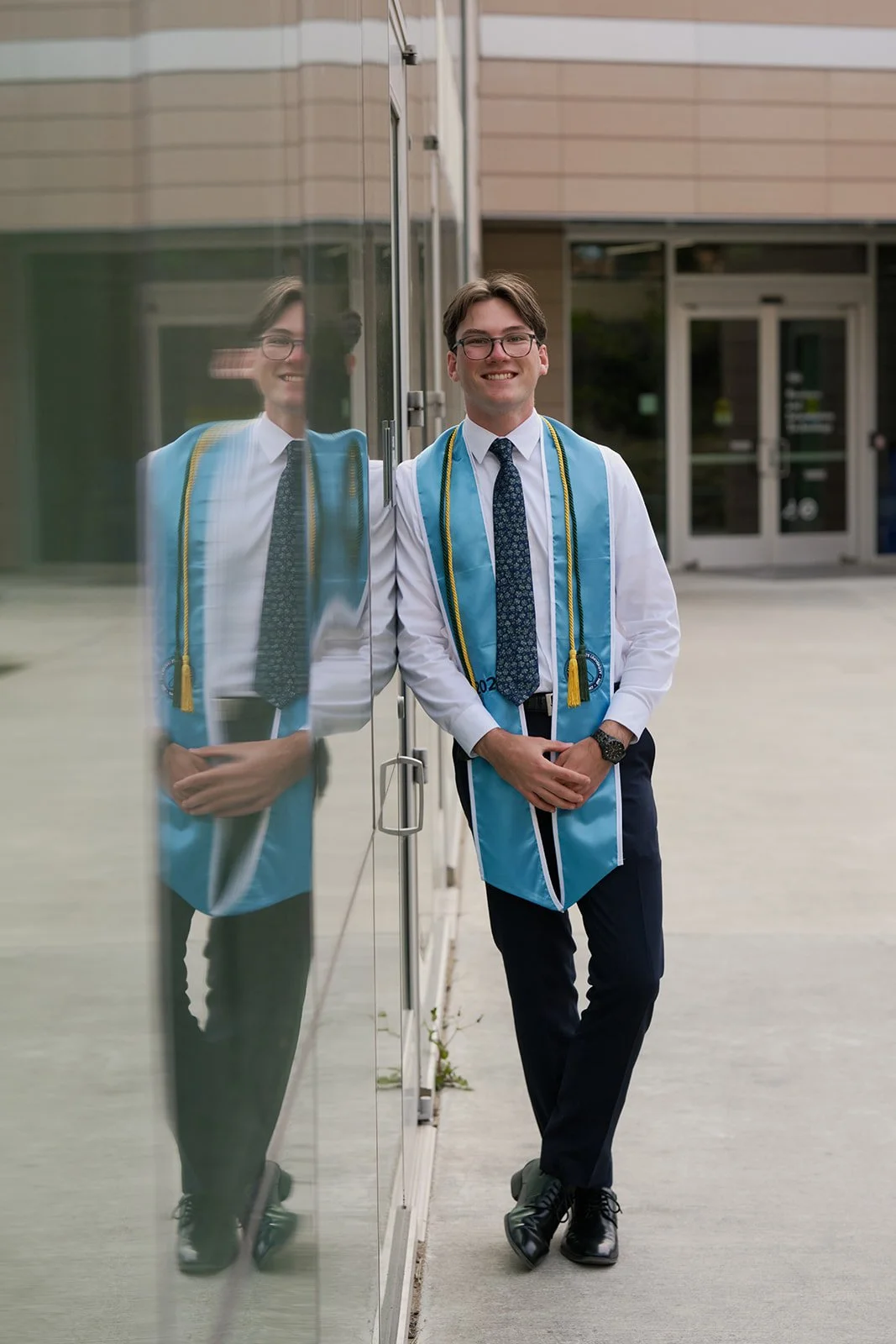 a young California State University Monterey Bay college graduate with his sash and formal clothes on campus