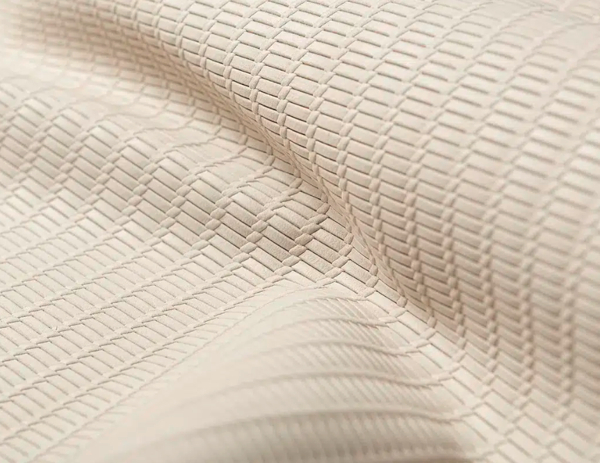 Close-up of textured beige fabric with a woven pattern.