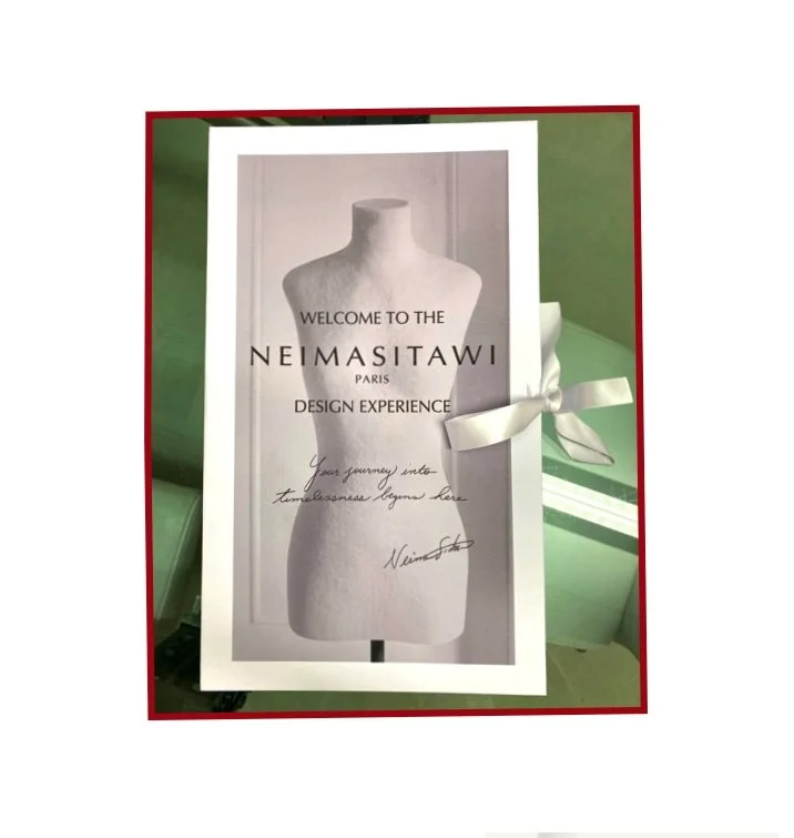Invitation or sign for Neimasitawi Paris Design Experience featuring a mannequin and a white ribbon.