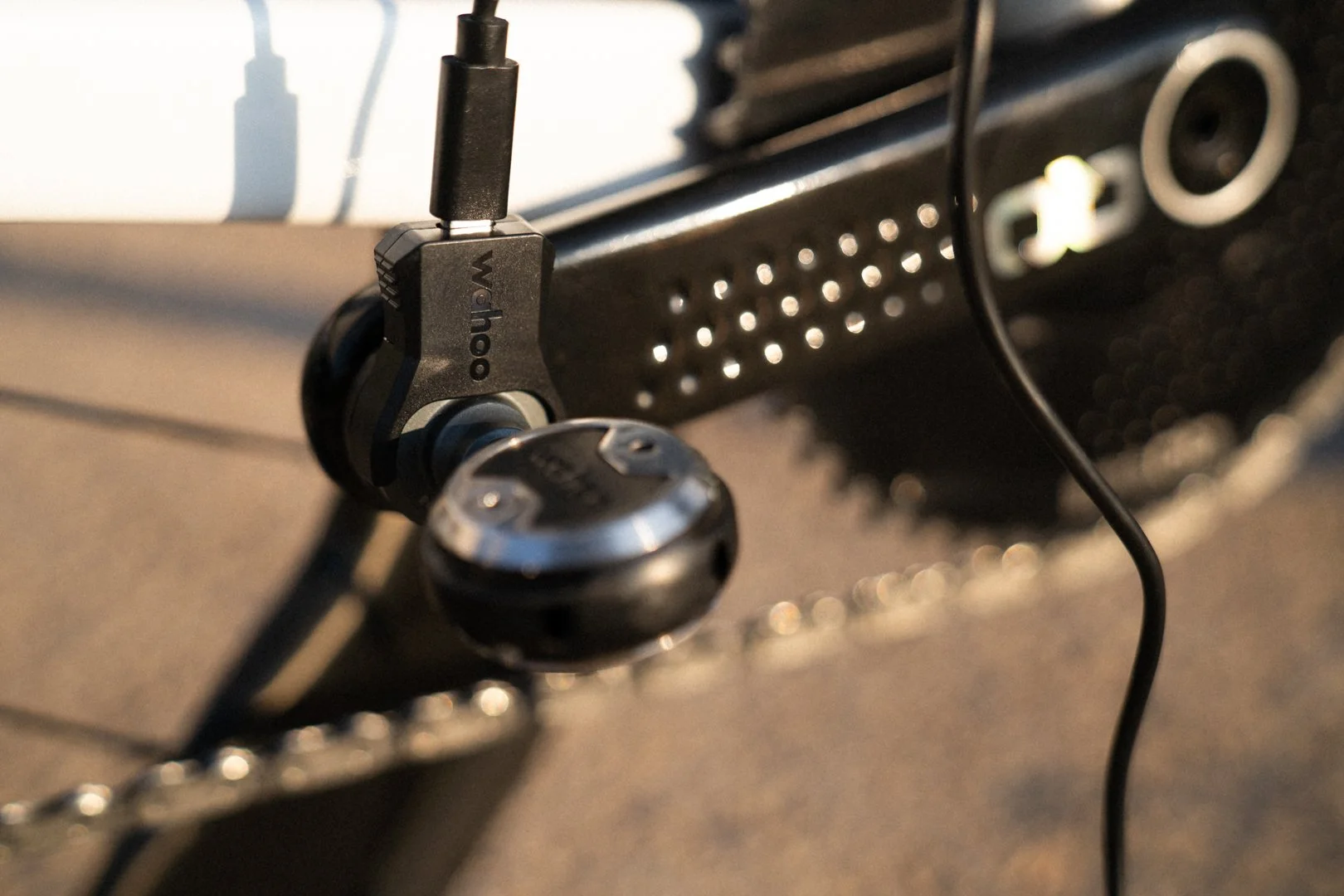 The magnetic charging clip attached to the power pod on a Wahoo Speedplay POWRLINK pedal, with a USB-C cable plugged into the top.