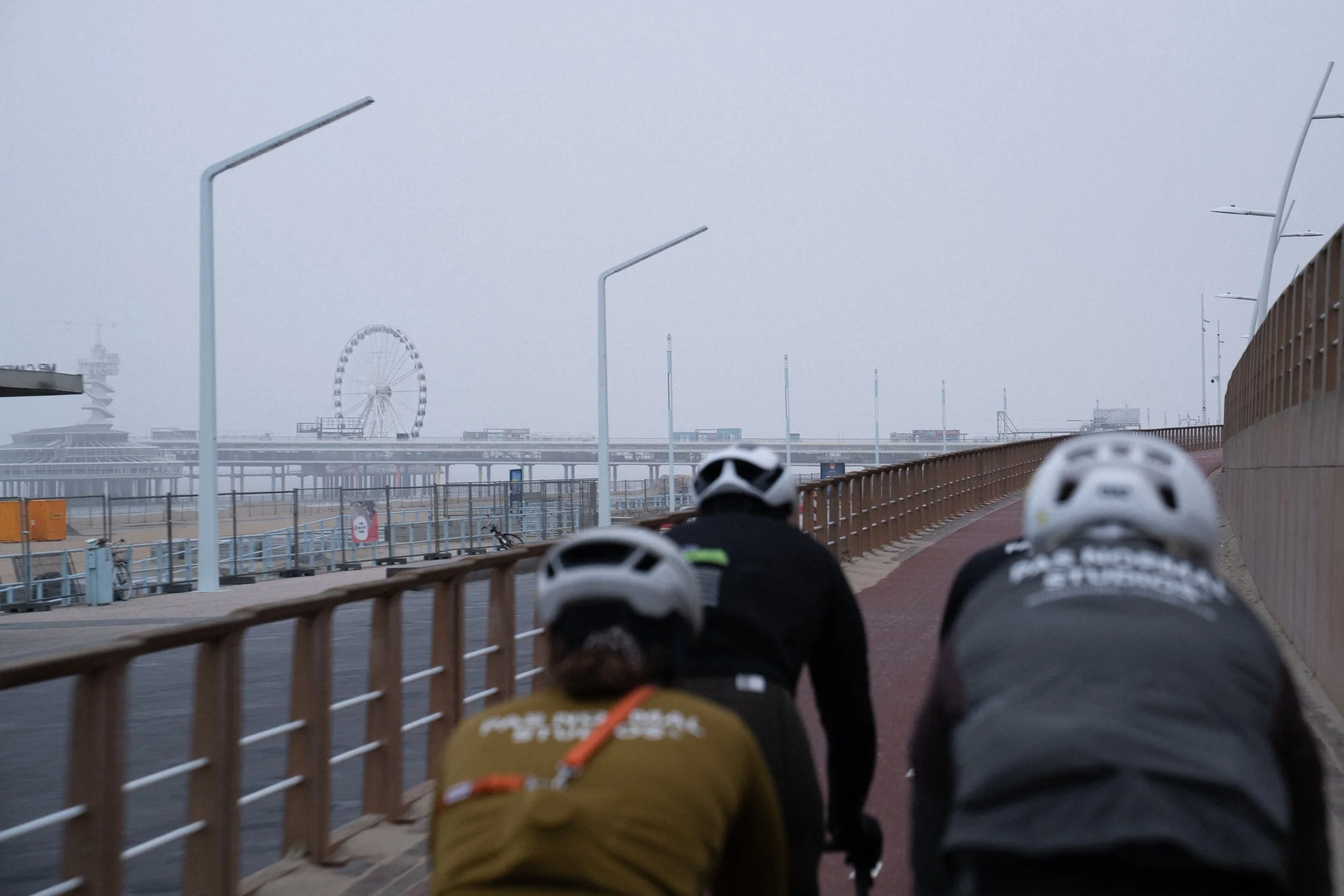 Group of cyclists cycling over the quiet boulevard of Scheveningen in mid winter.