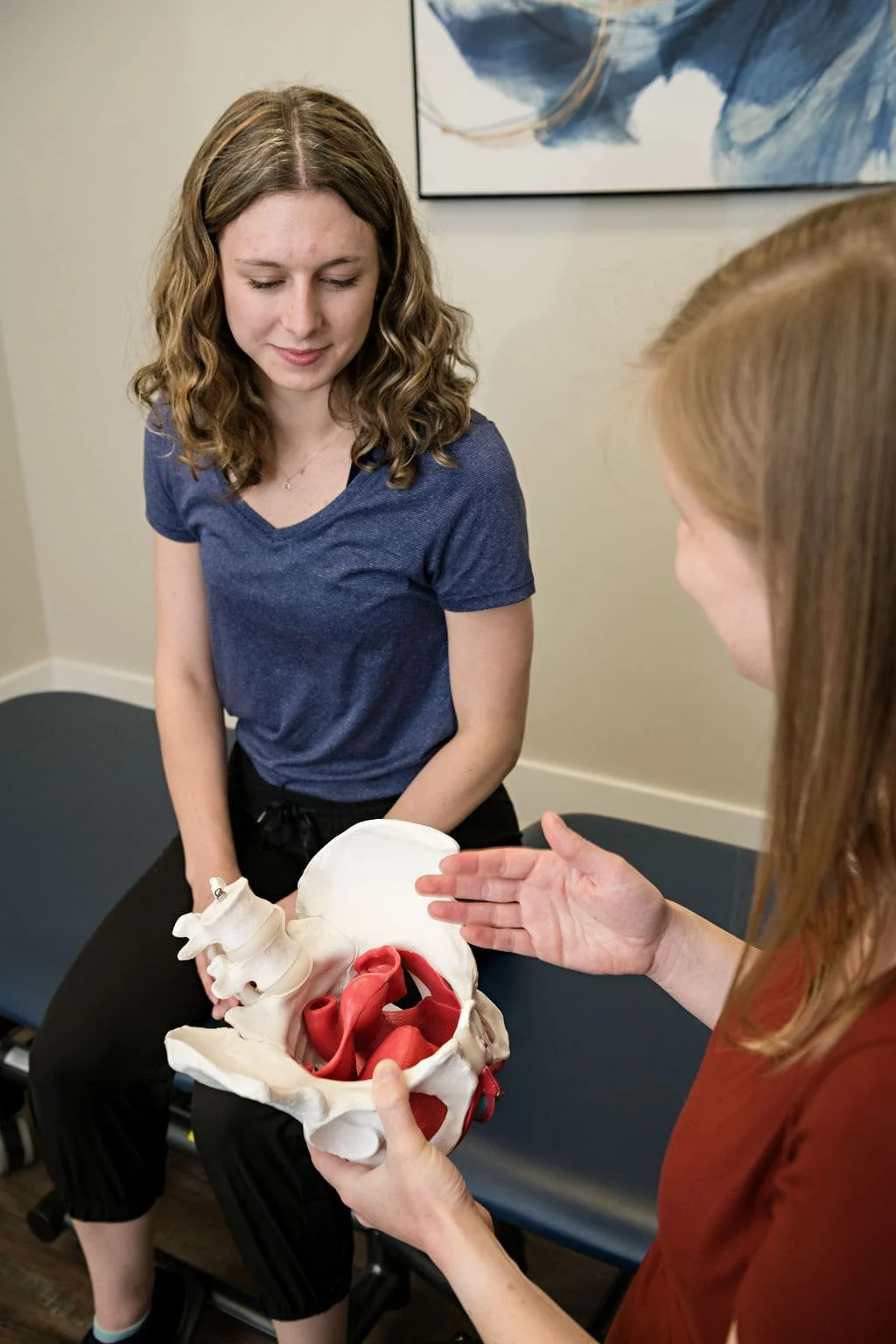 A pelvic floor physiotherapist at Break Free Physiotherapy in London, Ontario completing a physiotherapy assessment for a postpartum mom who is experiencing prolapse and urinary incontinence
