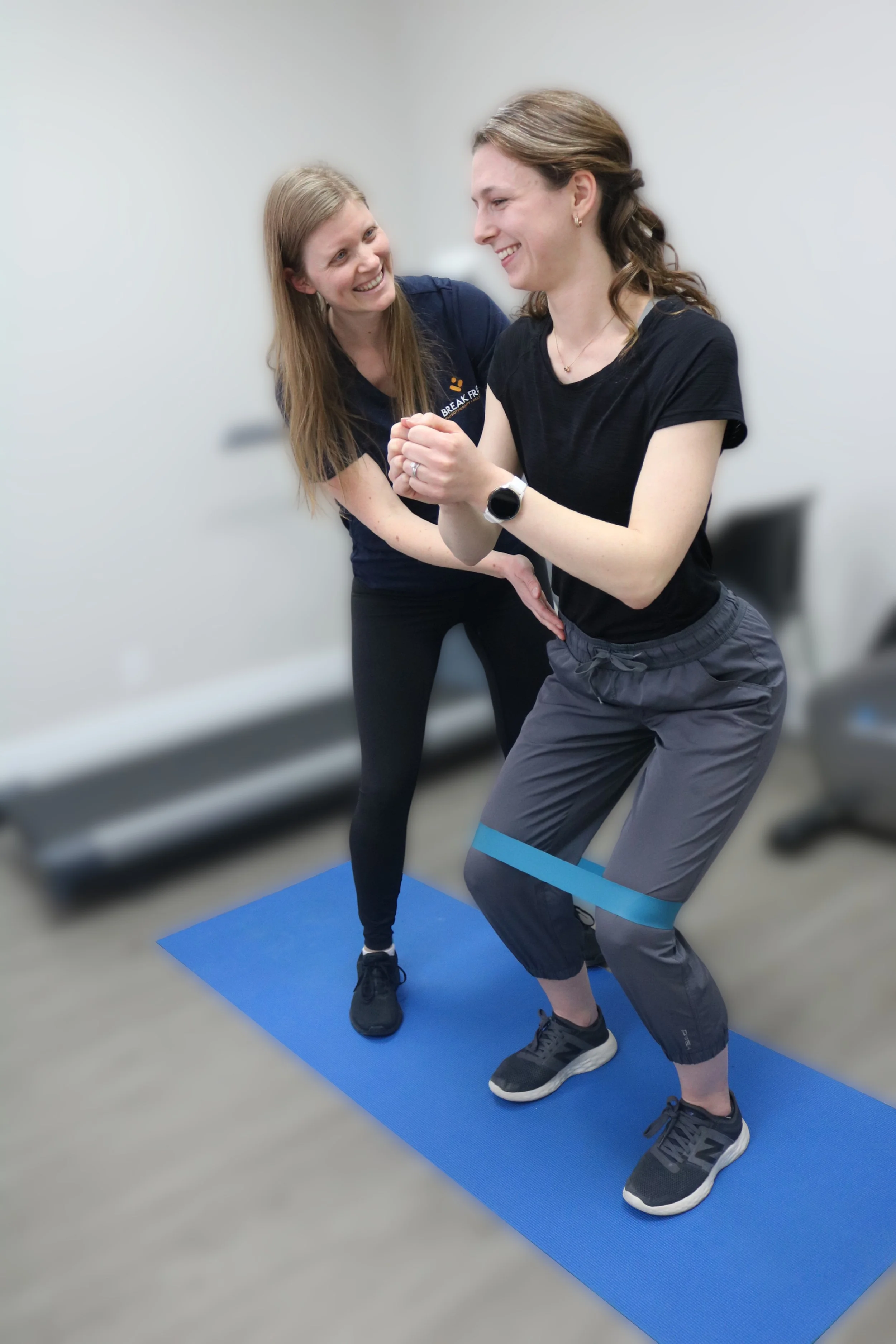 Jessica Tomlin, pelvic physiotherapist in London, Ontario, teaching a postpartum mom proper squat form during a group rehab class