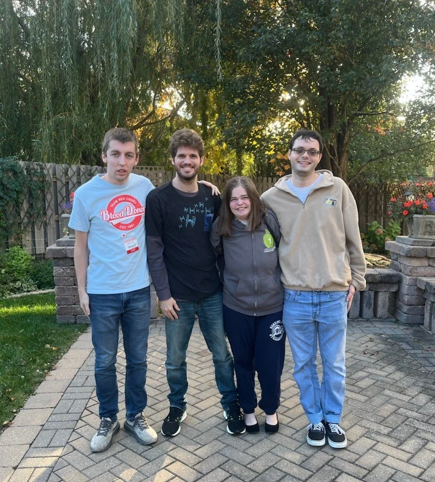 4 adults smiling for a group photo