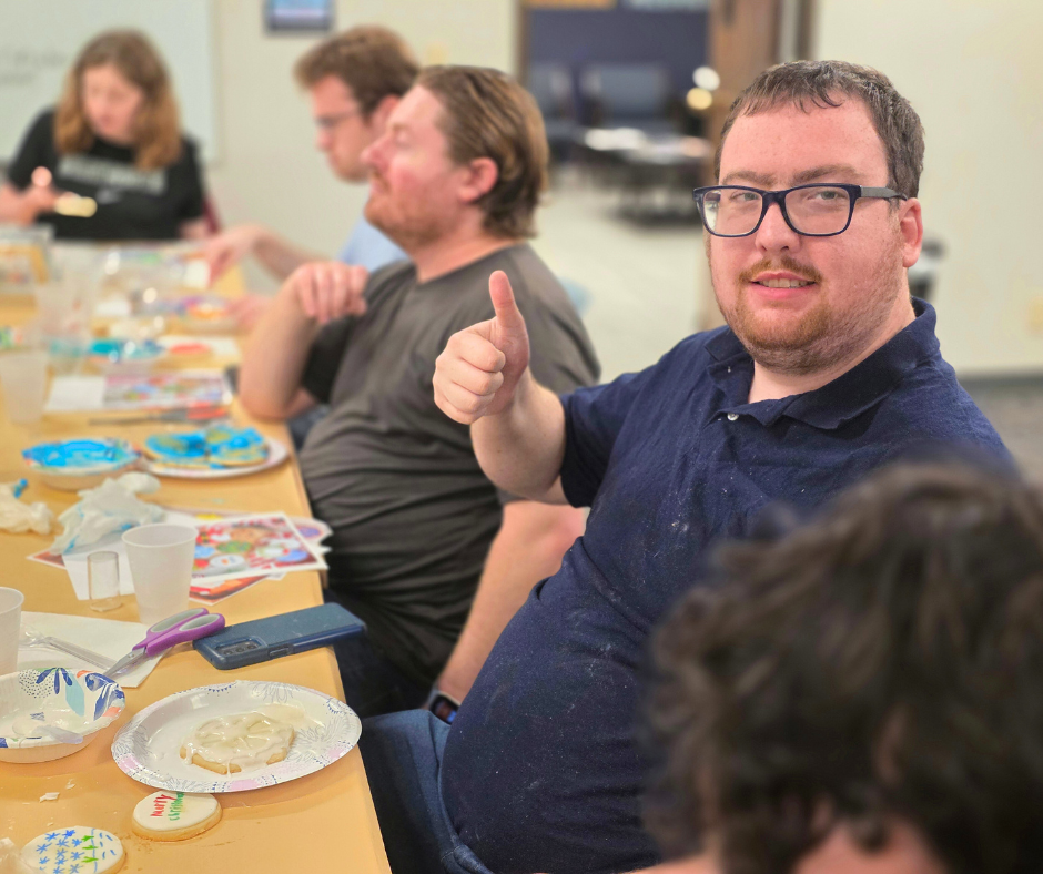Person holding thumb up while cookie decorating
