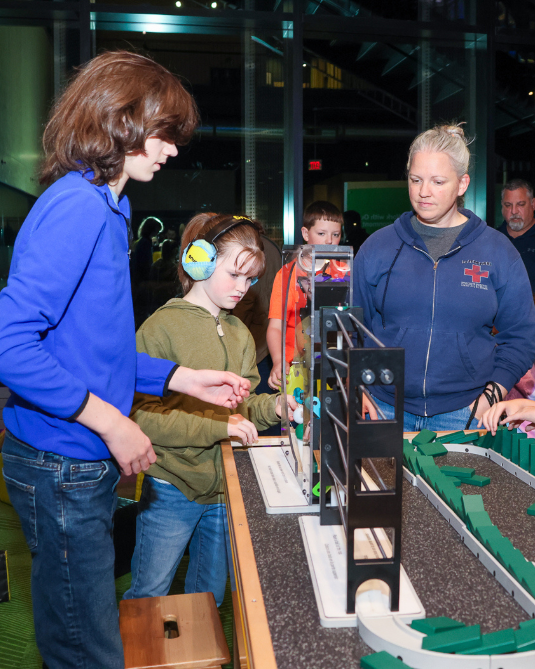 Children gather around an experiment at a museum.