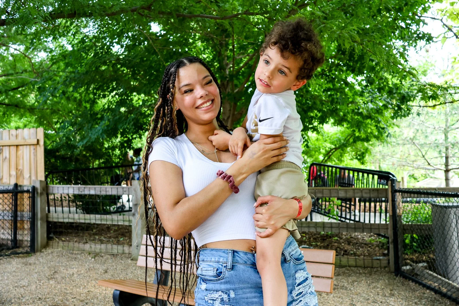 A mother posing with her child outside.
