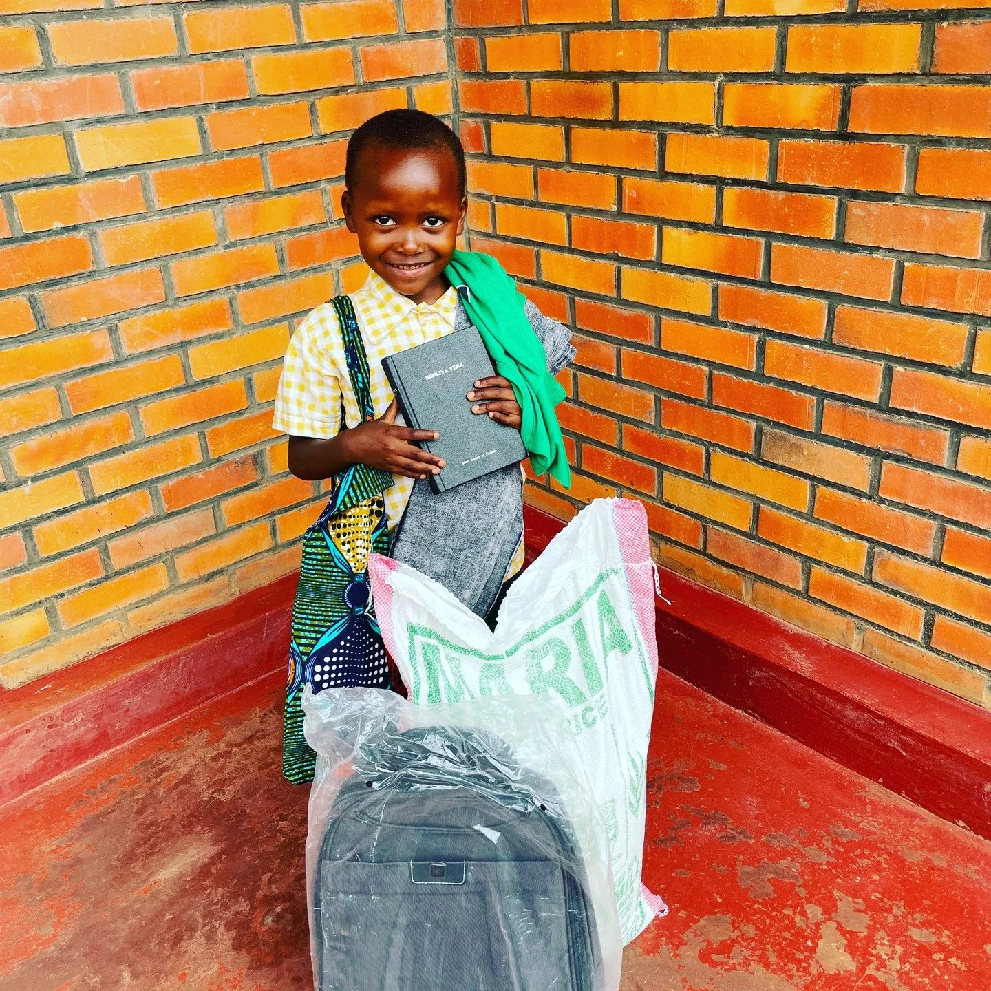 Giving truly does make a heart sing. This is a photo of sweet Asifiwe, an adorable boy who me and my husband support in Rwanda. He is pictured with his new backpack, Bible, and other supplies for school and his family. What an honor it is to be able 