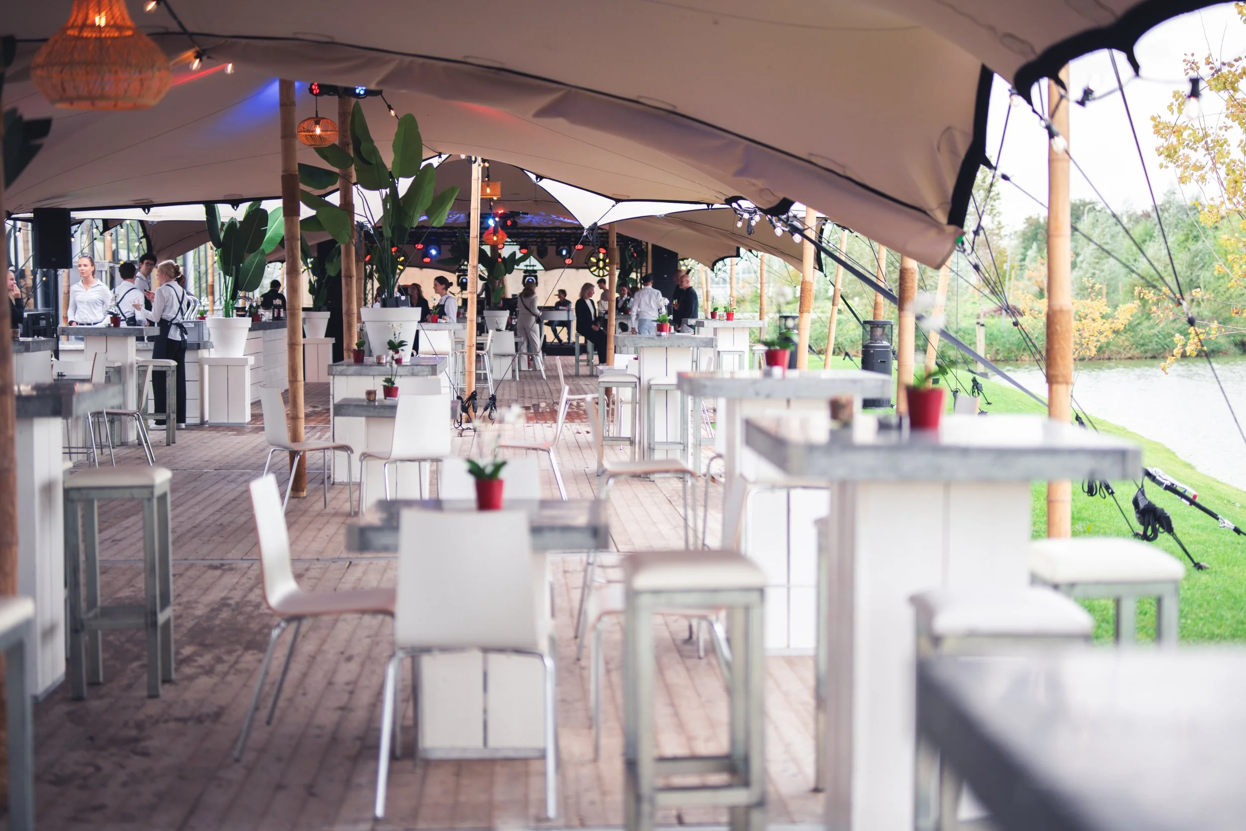 Sfeervolle stretchtent met stijlvolle inrichting en witte meubels langs het water, verzorgd door eventplanner Maarten Huisman van MPPR voor een exclusief bedrijfsfeest