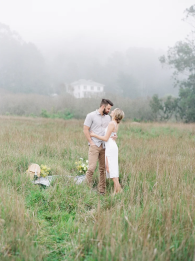 couple embracing in foggy coastal meadow during engagement session, mendocino northern california — film portrait photography by Radostina Boseva