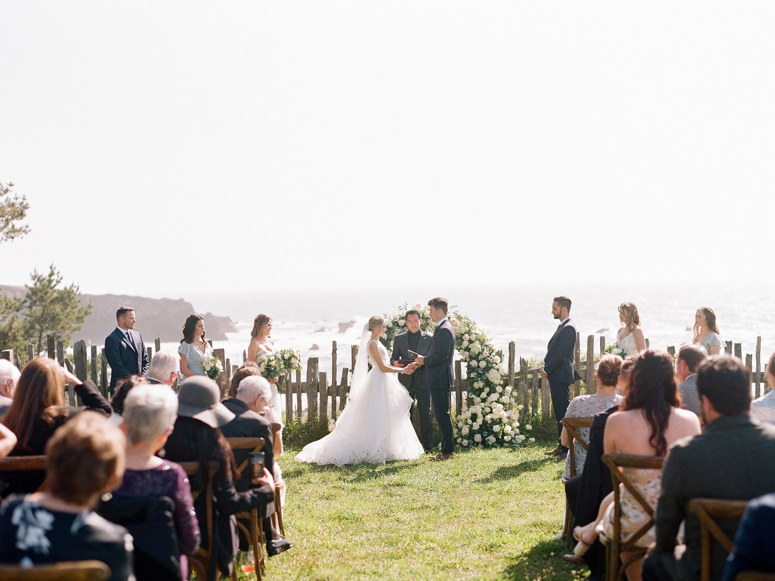 Wedding ceremony on coastal meadow with ocean backdrop, bride and groom at the altar, photographed on film in Mendocino in Switzer Farm