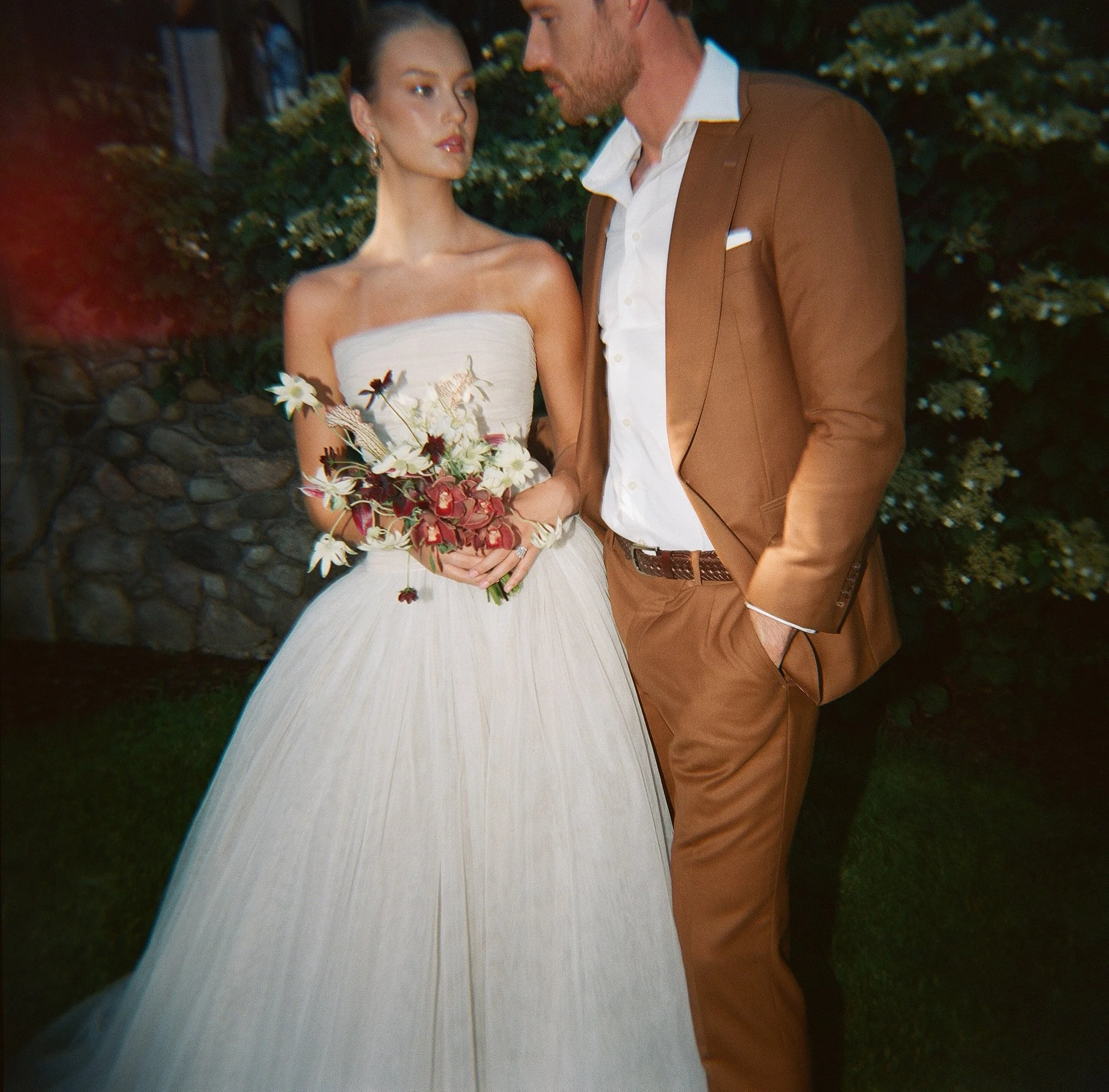 Bride in strapless tulle gown and groom in caramel suit at evening wedding portrait — documentary film wedding photography, San Francisco