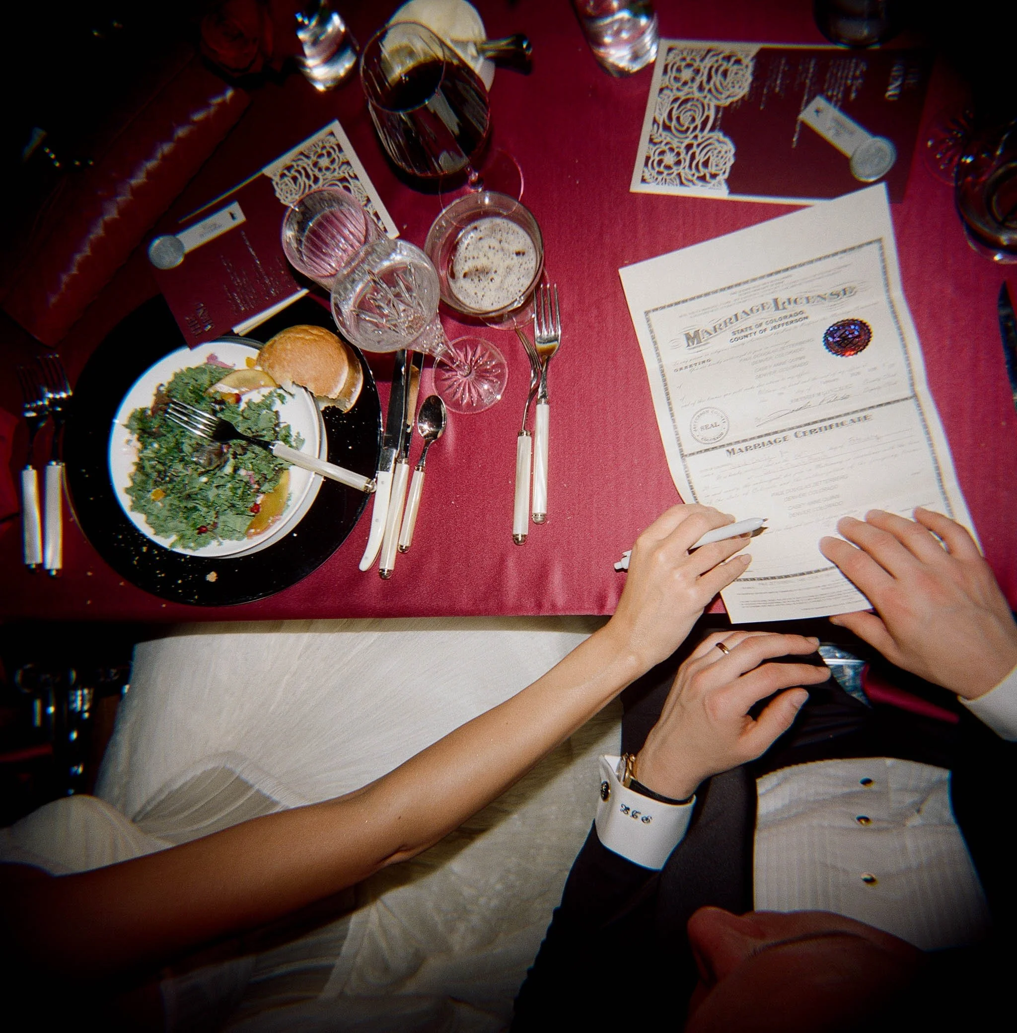 Candid overhead documentary moment of couple signing marriage license at wedding — film photography by Radostina Boseva