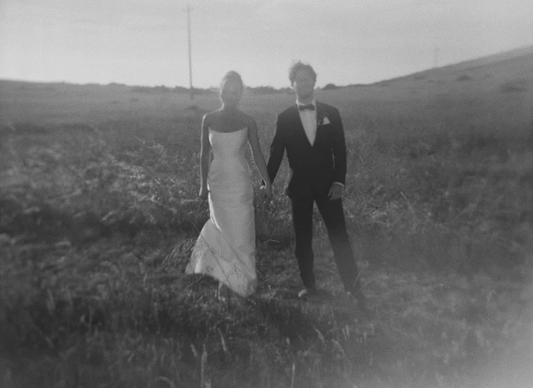 Bride and groom standing in open field at dusk, black and white film wedding portrait in Mendocino in Cuffey Cove