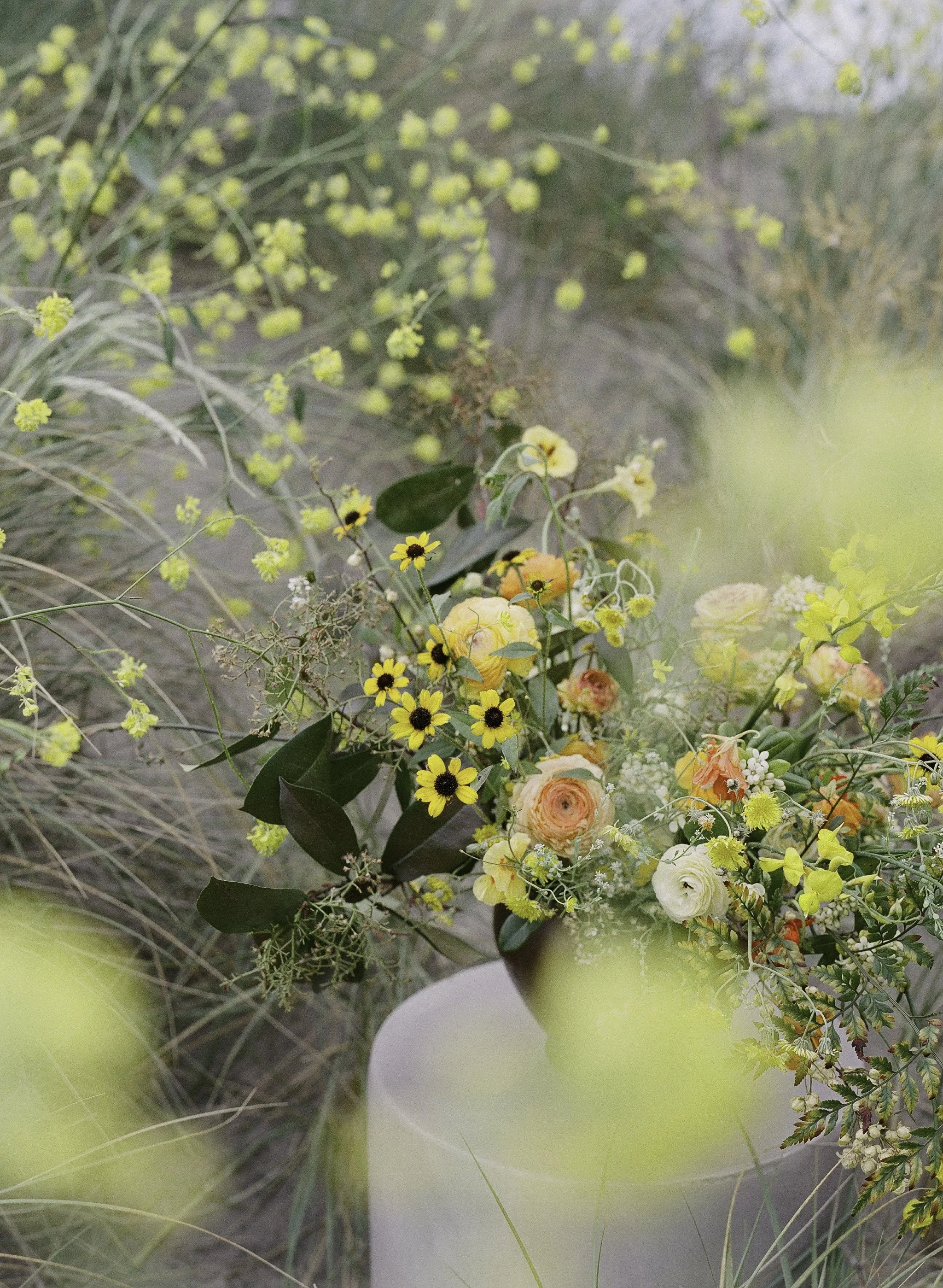 Bridal bouquet of ranunculus and wildflowers against coastal grasses, film wedding photography, Big Sur wedding photographer California