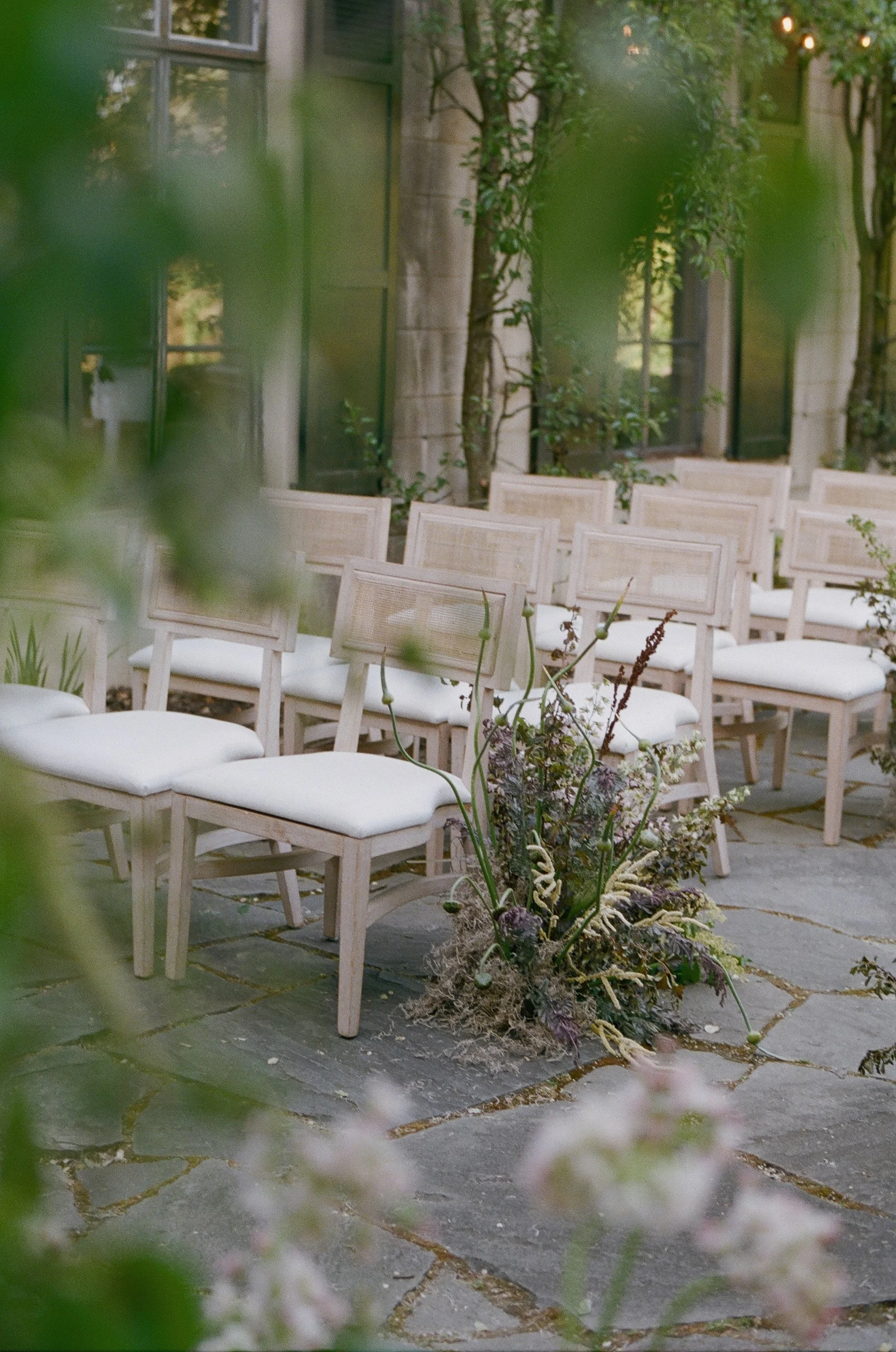 Outdoor ceremony setup at Flood Mansion in San Francisco — garden courtyard with white chairs and floral arrangements, film wedding photography