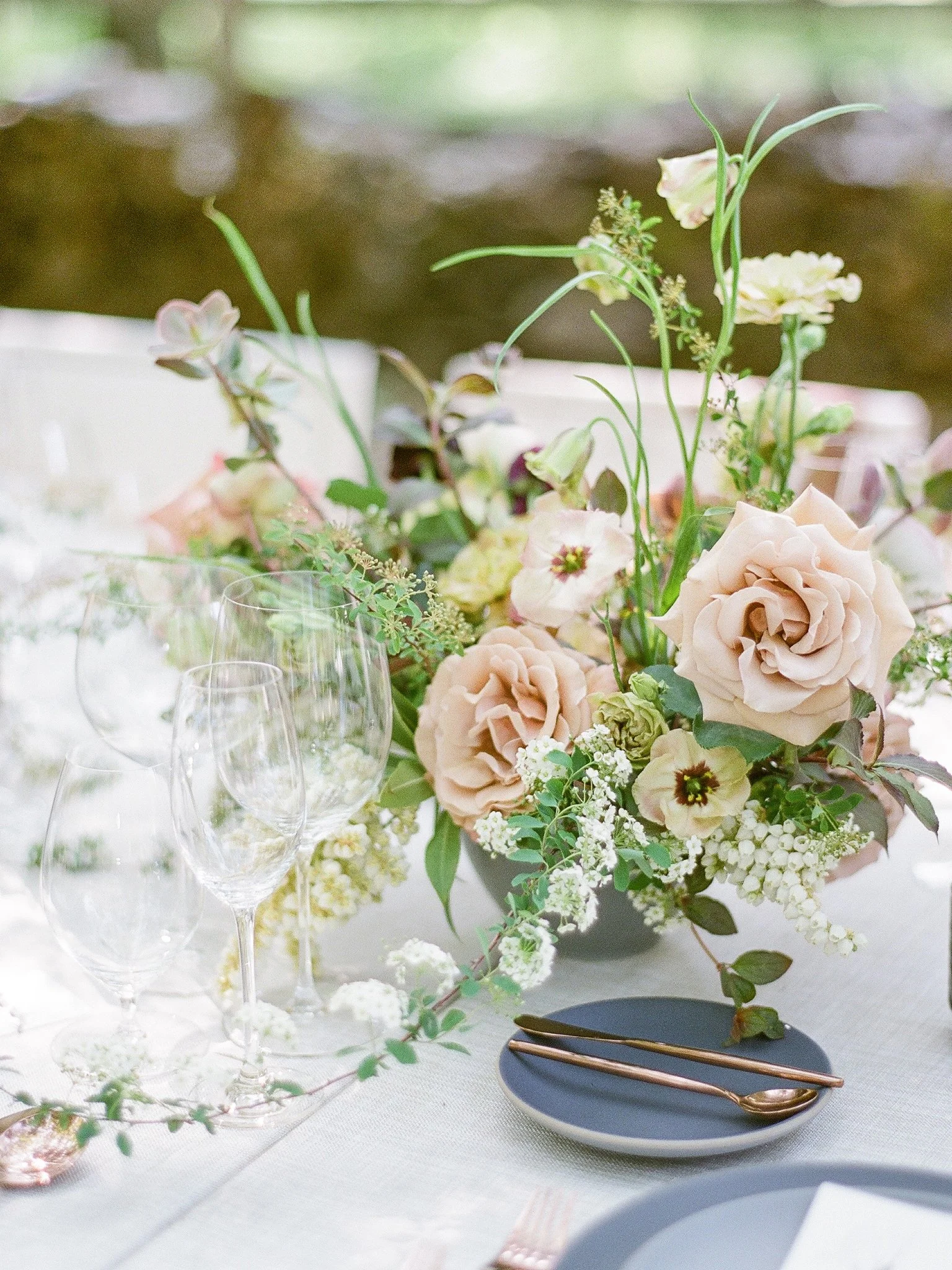 Outdoor wedding reception table with blush roses and wildflower centerpiece, photographed on film in Mendocino