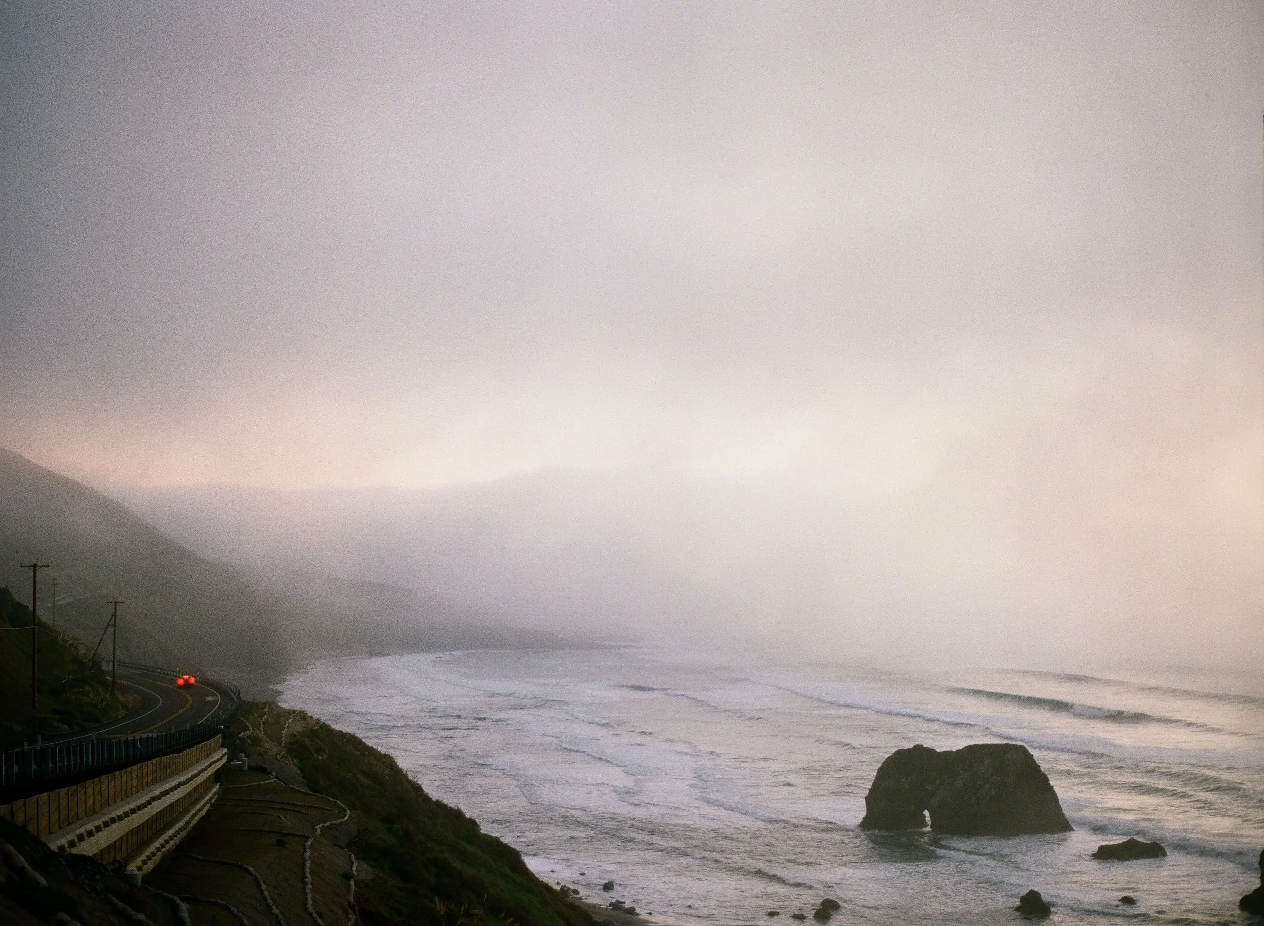 Foggy Northern California coastline with winding highway at dusk, film photography in Mendocino
