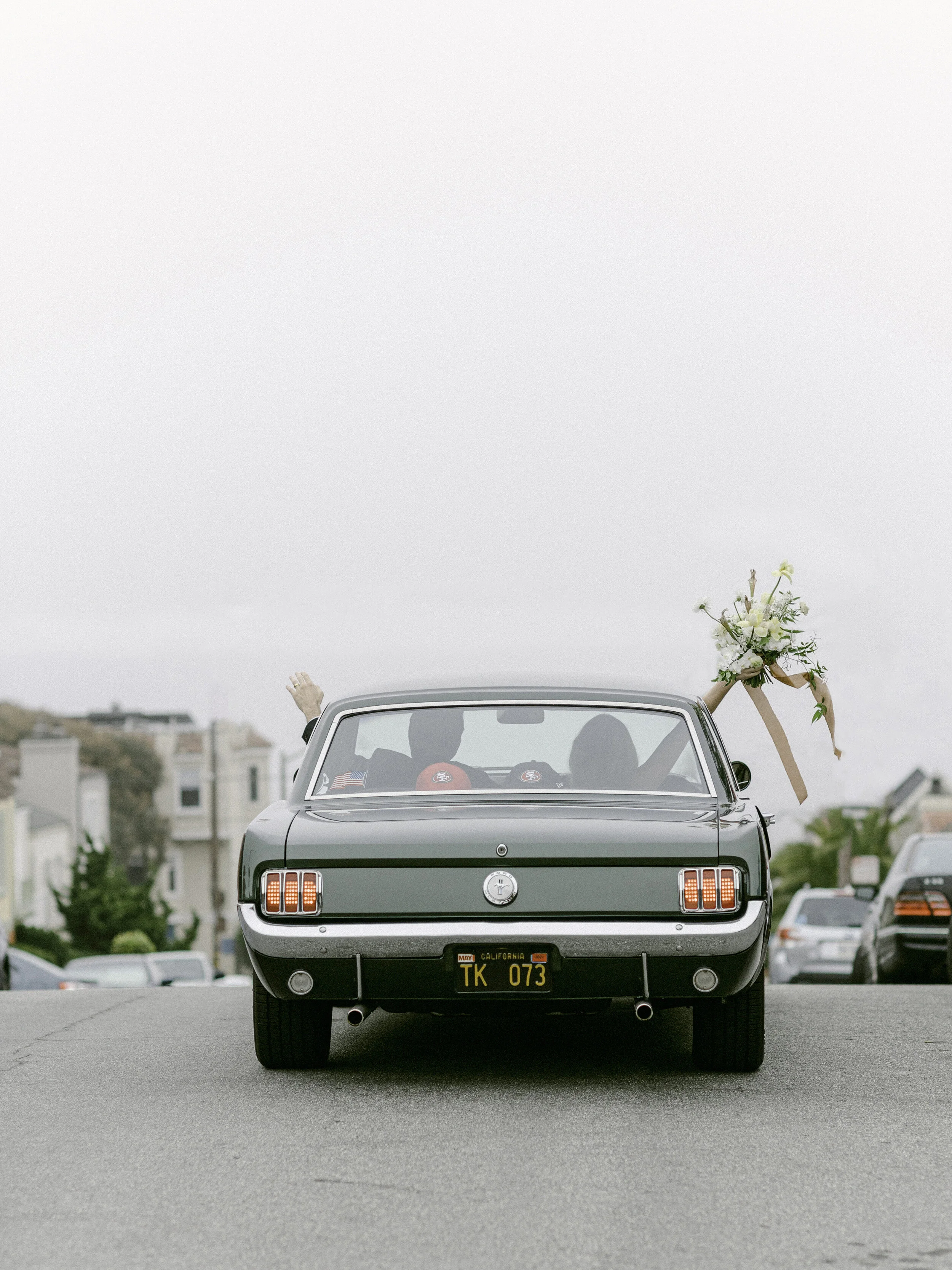 Documentary wedding exit in vintage car on San Francisco street — film photography by Radostina Boseva