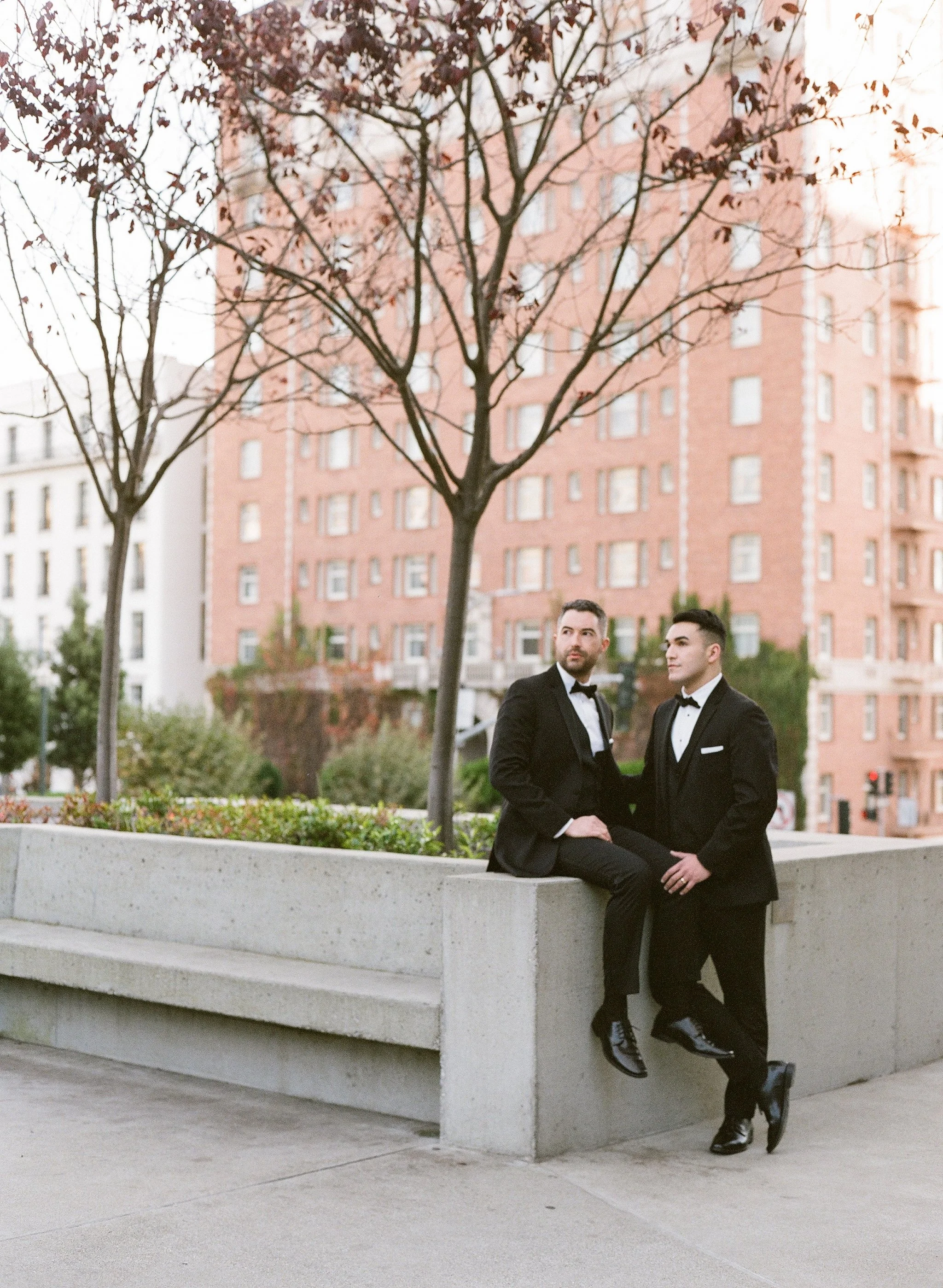 Same-sex couple portrait in tuxedos at urban Los Angeles wedding — film wedding photography by Radostina Boseva