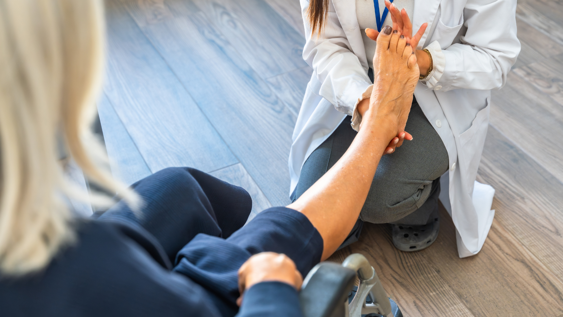 Physiotherapist examining a patient's foot and ankle during a home visit session.
