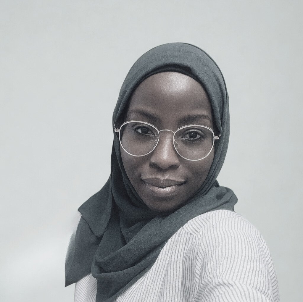 Female with dark hair and a top with Home Physio Company on the back holding a massage table approaching a front door