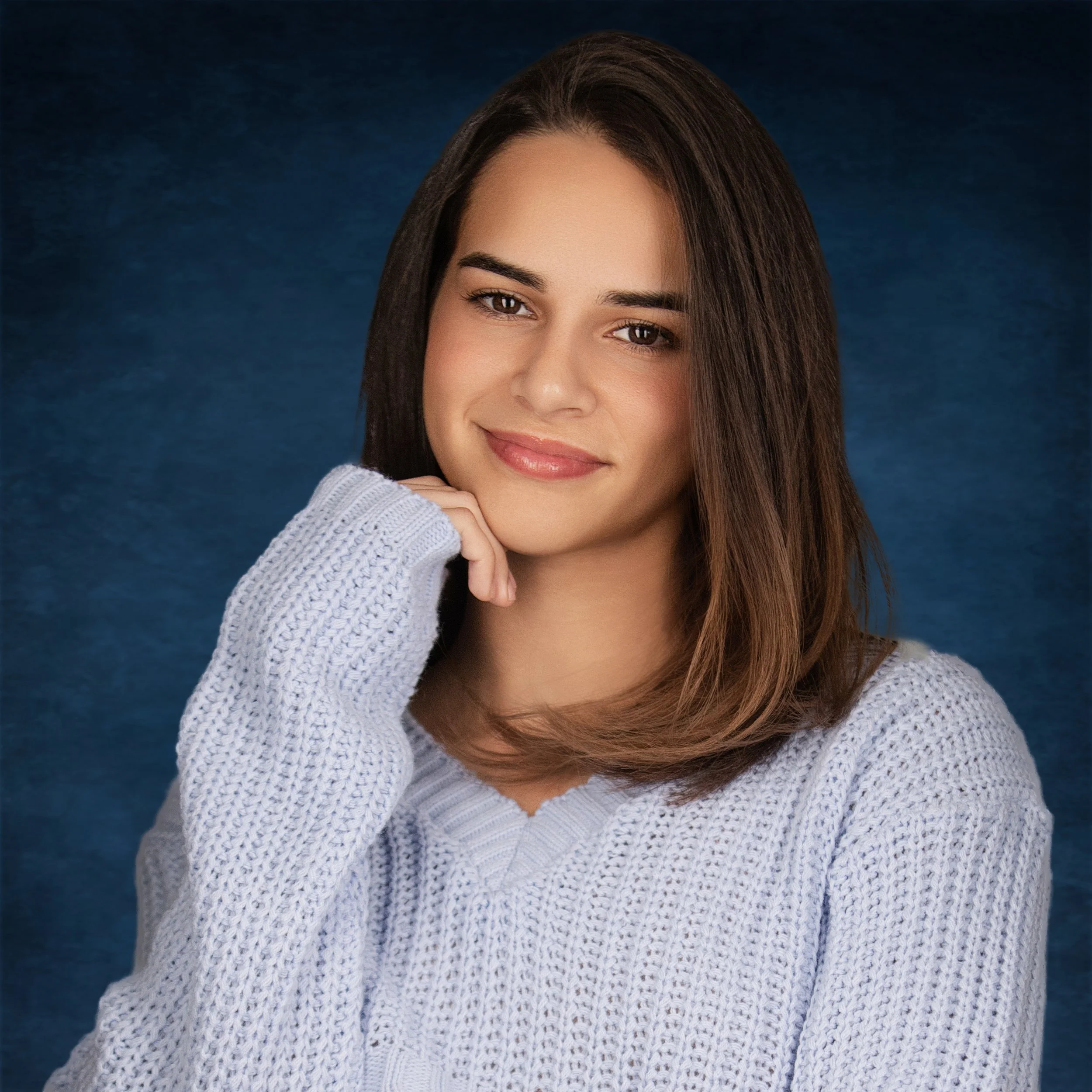 Professional female headshot photographed at a Kendall, Miami studio, featuring a friendly expression against a blue background.