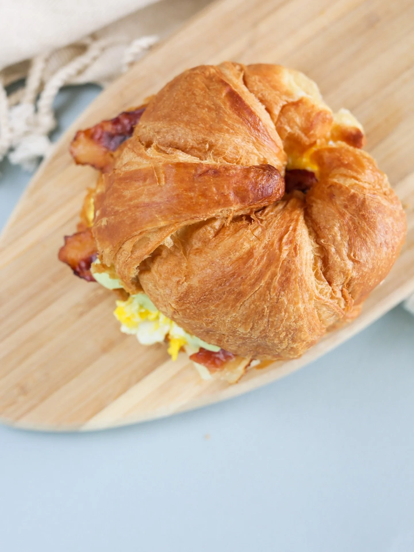 Surf. Eat. Repeat. 🤙
🥐 Dawn Patrol Breakfast Sandwich 
Light & fluffy cage-free eggs, savory cheese, piled with crispy bacon, & topped with a delicious avocado aioli. This is our go-to post-surf breaky. Served on a warm, buttery croissant.