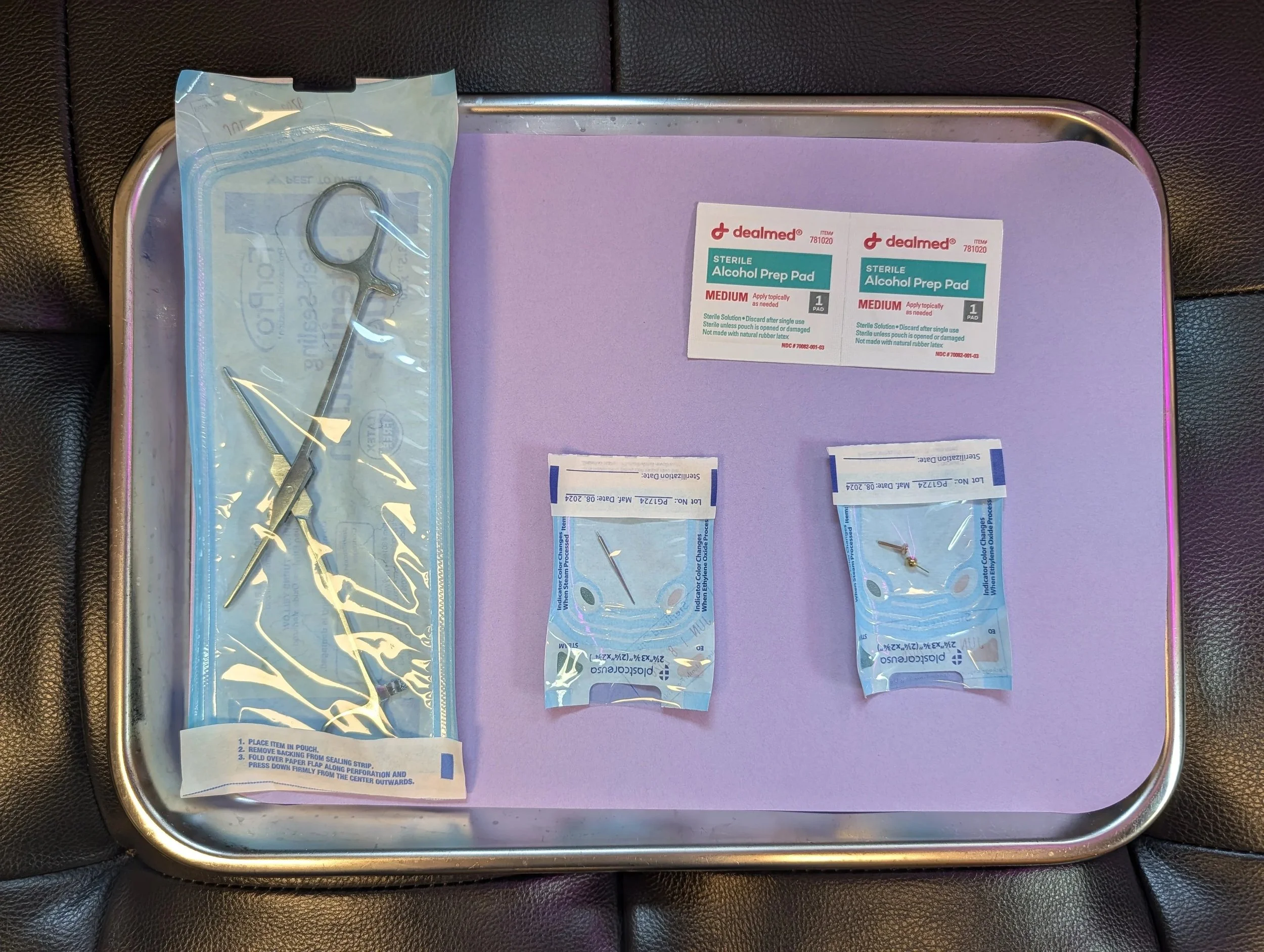A sterile piercing tray set up showcasing titanium jewelry and sterile hemostats
