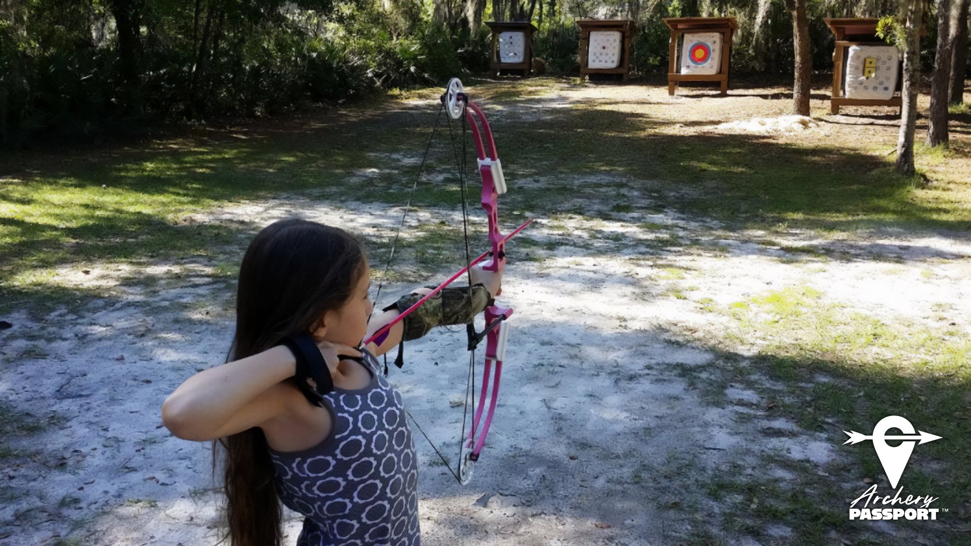 Female youth shooting compound bow at outdoor target (Copy) (Copy) (Copy)
