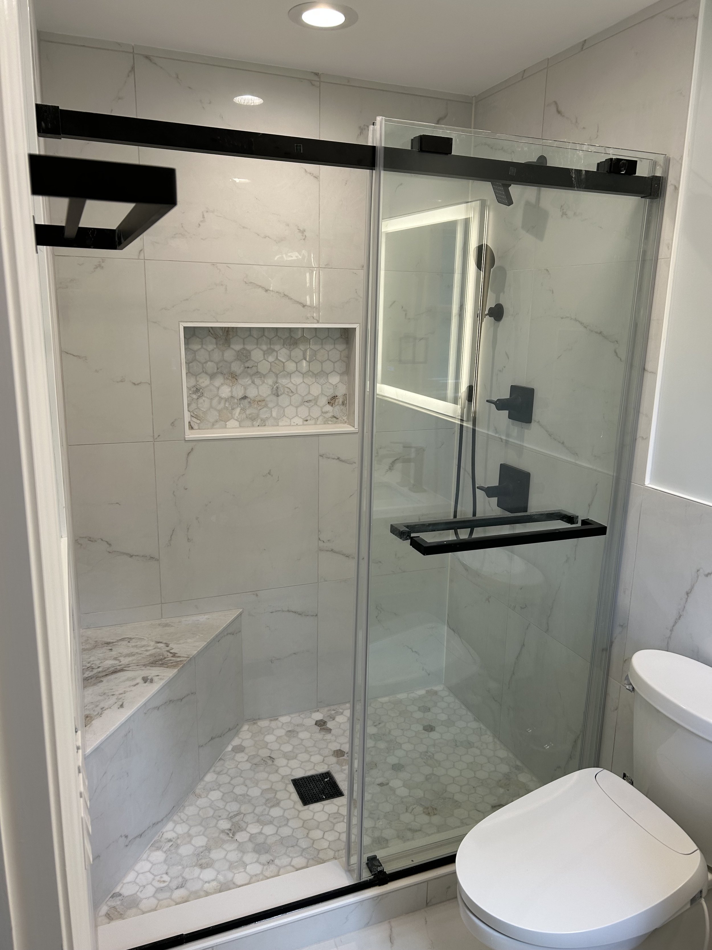 Shower with corner bench and sliding glass door in Darian, CT