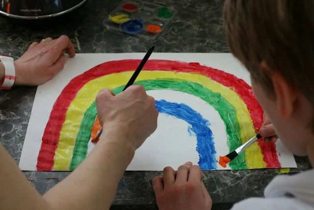 child and art therapist doing painting together