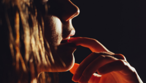 A woman biting her lip in a sexy way