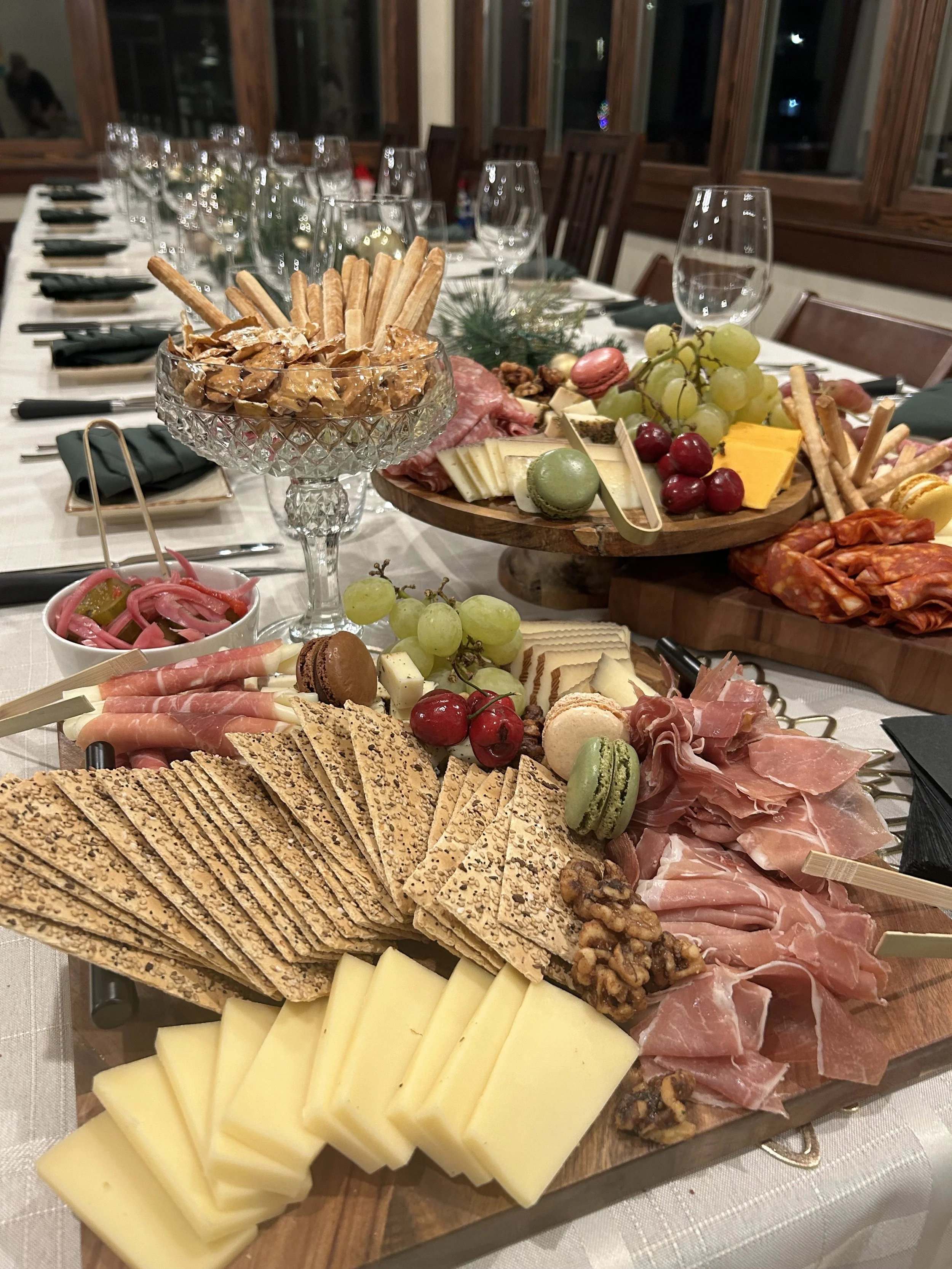 A charcuterie grazing table featuring cured meats, cheeses, and assorted accoutrements displayed at the end of a plated dinner table, catered by Lone Peak Provisions for an event in Bozeman, Montana.