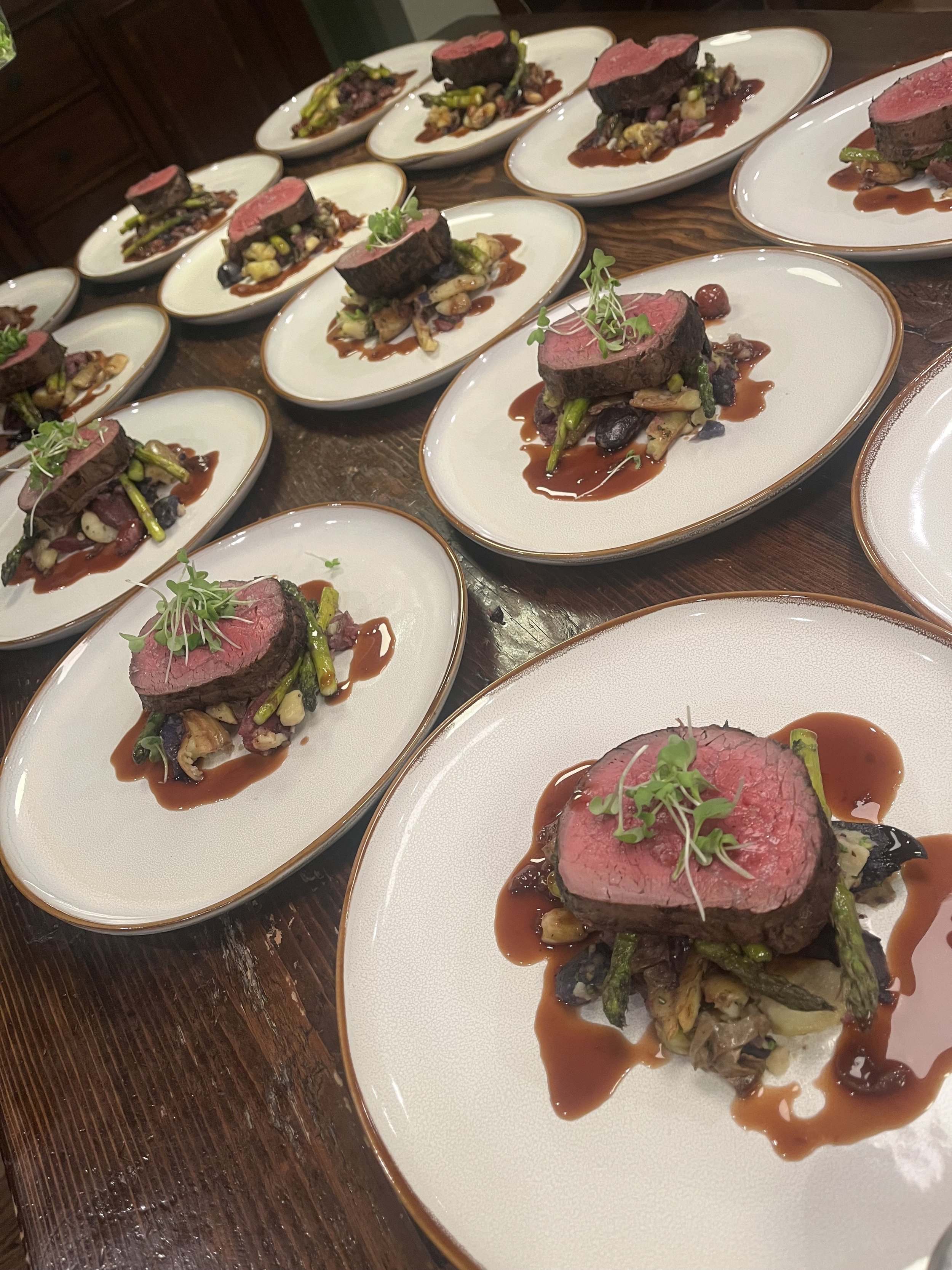 A petite filet served over scalloped potatoes and asparagus as a plated dinner entrée option for catered events by Lone Peak Provisions in Bozeman, Montana.