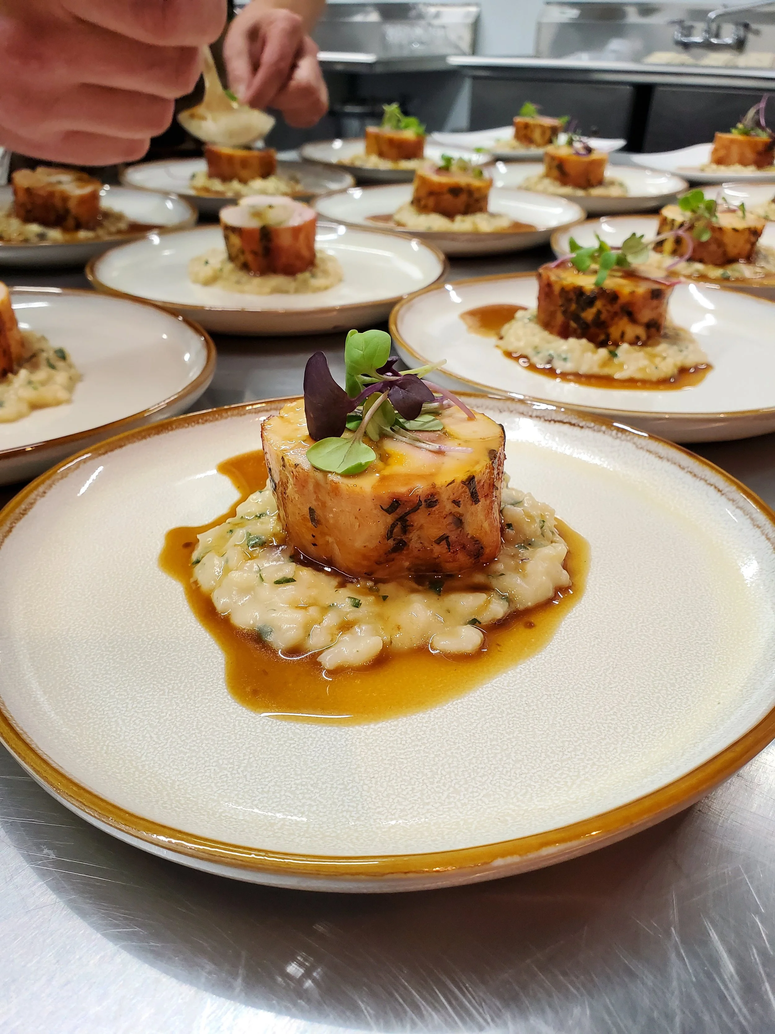 Chicken roulade with demi glace served over lemon risotto as a plated dinner entrée option for catered events by Lone Peak Provisions in Bozeman, Montana.