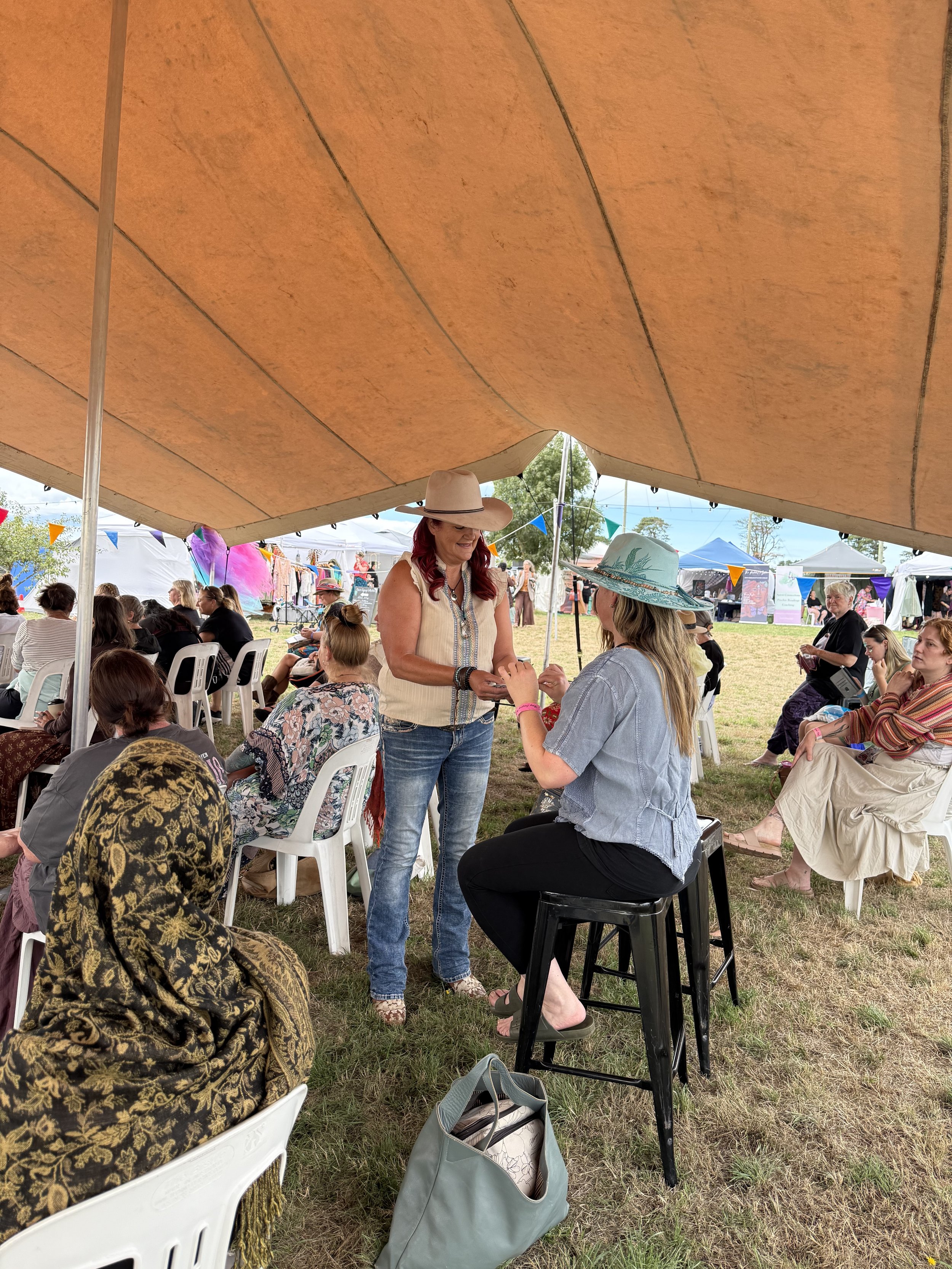 Tonia, The Cowgirl Medium, giving audience readings at a festival.