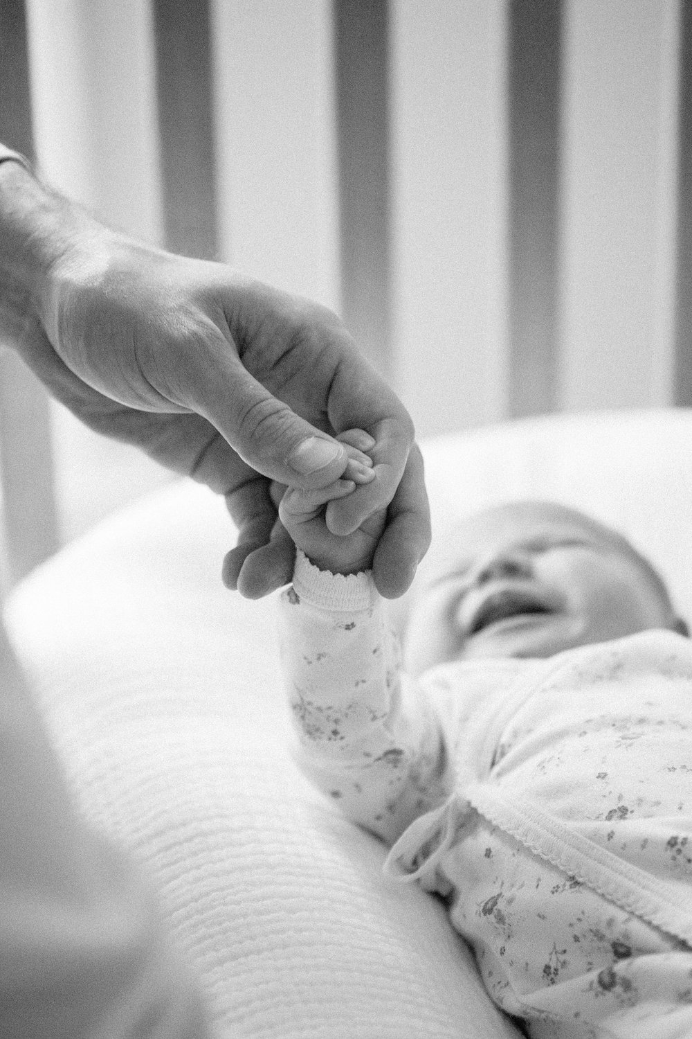 holding newborn baby's tiny hand